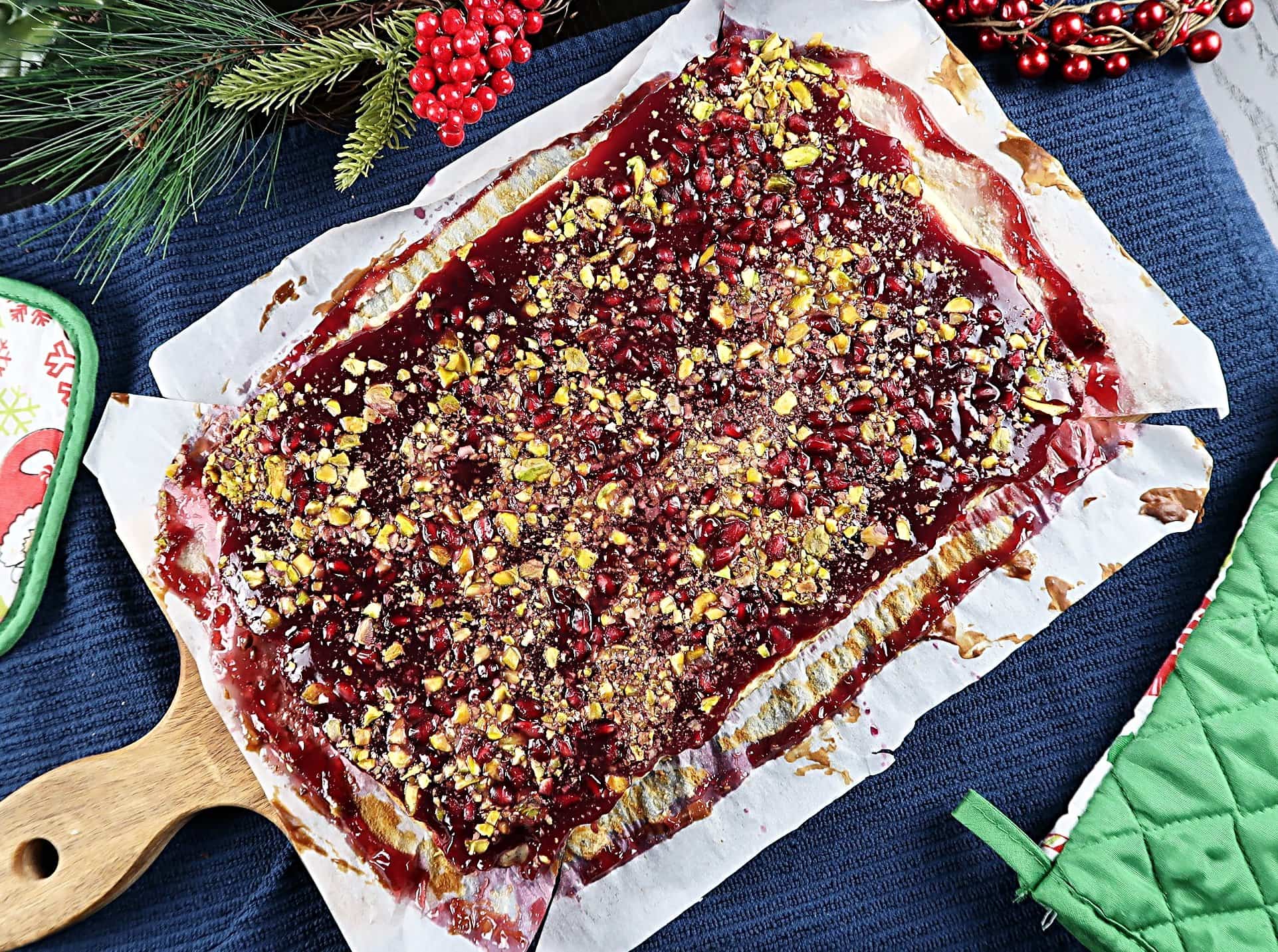 Pomegranate Pistachio Cheesecake Bars cooling on a serving board