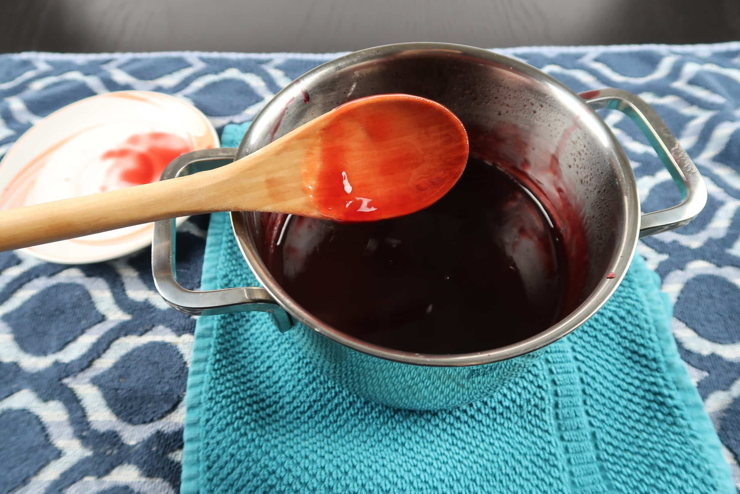 A pot of bright red pomegranate sauce.