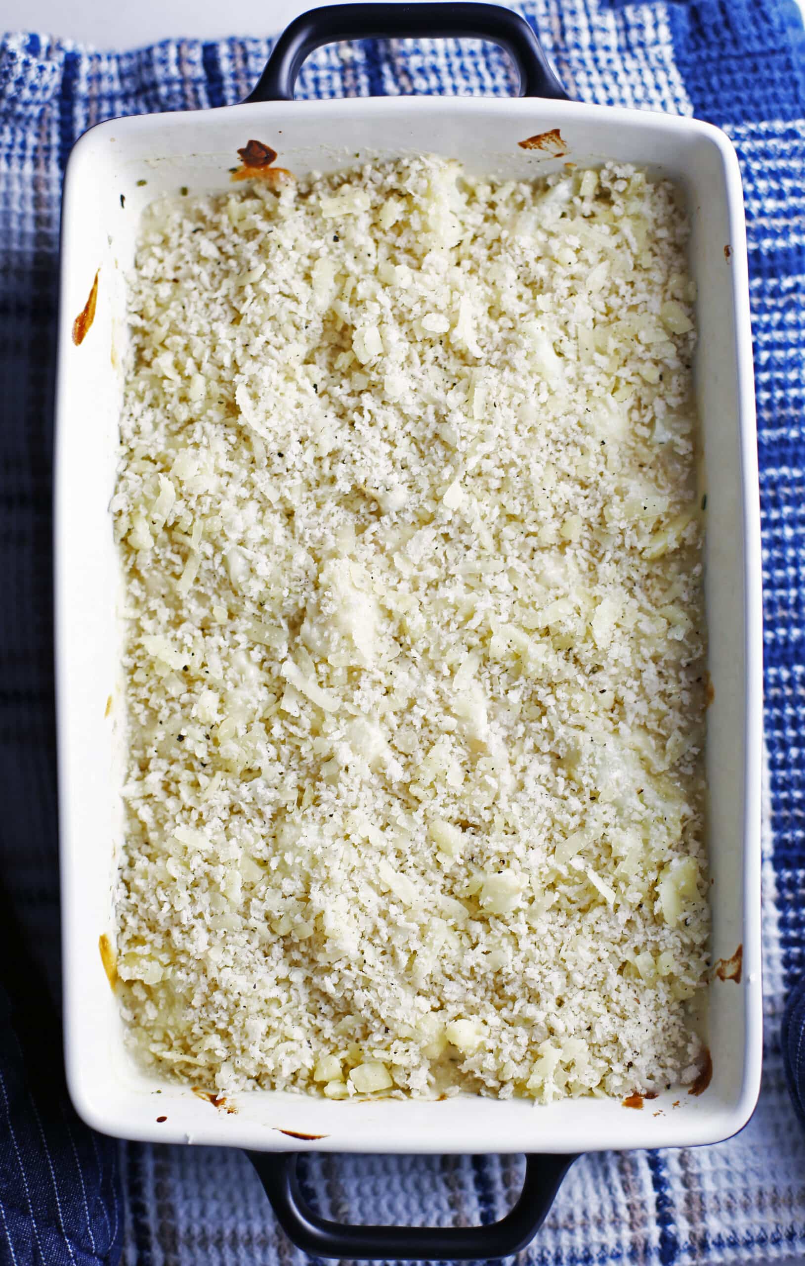 Cauliflower gratin with breadcrumbs in a casserole dish ready to be baked.