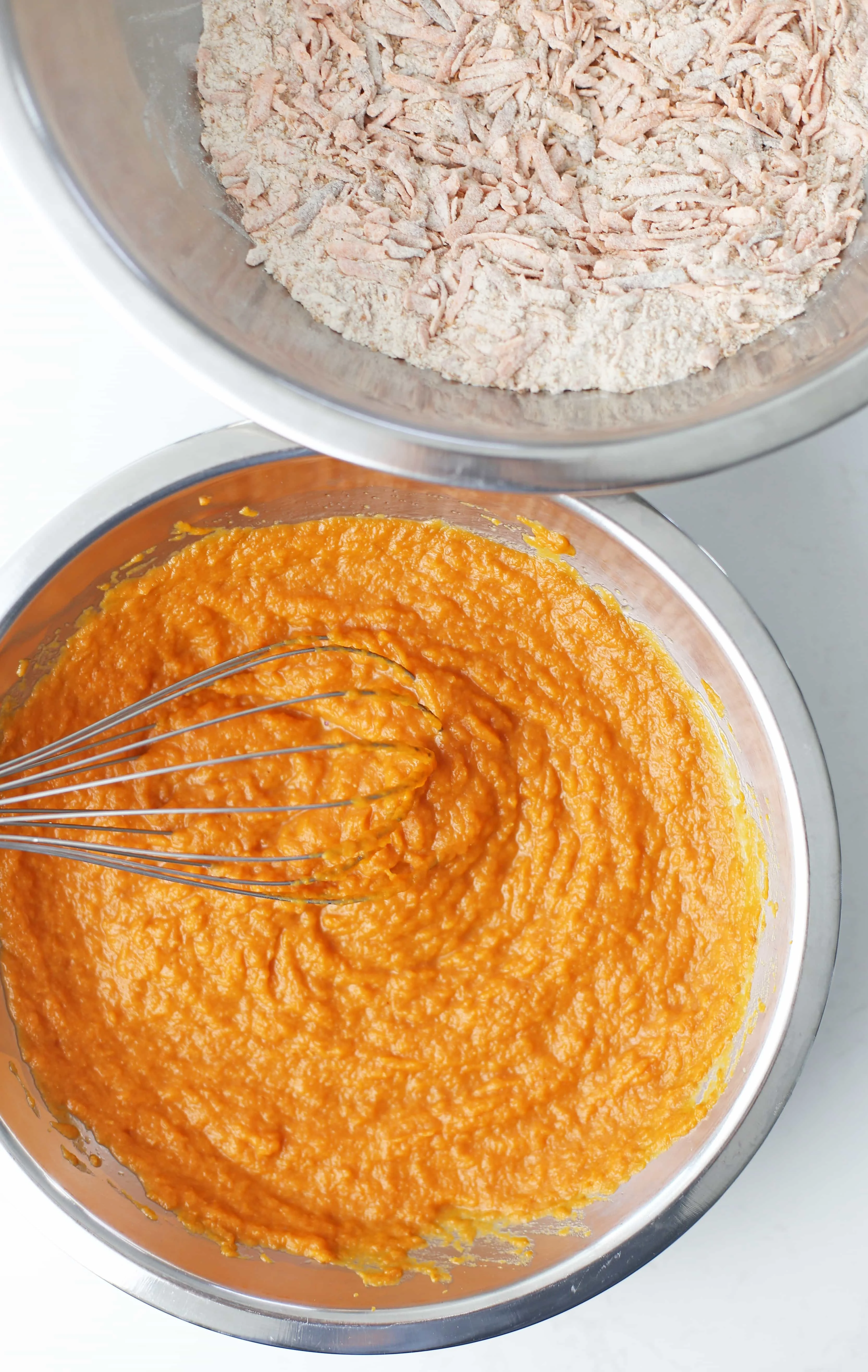 Wet and dry baking ingredients in two stainless steel bowls.