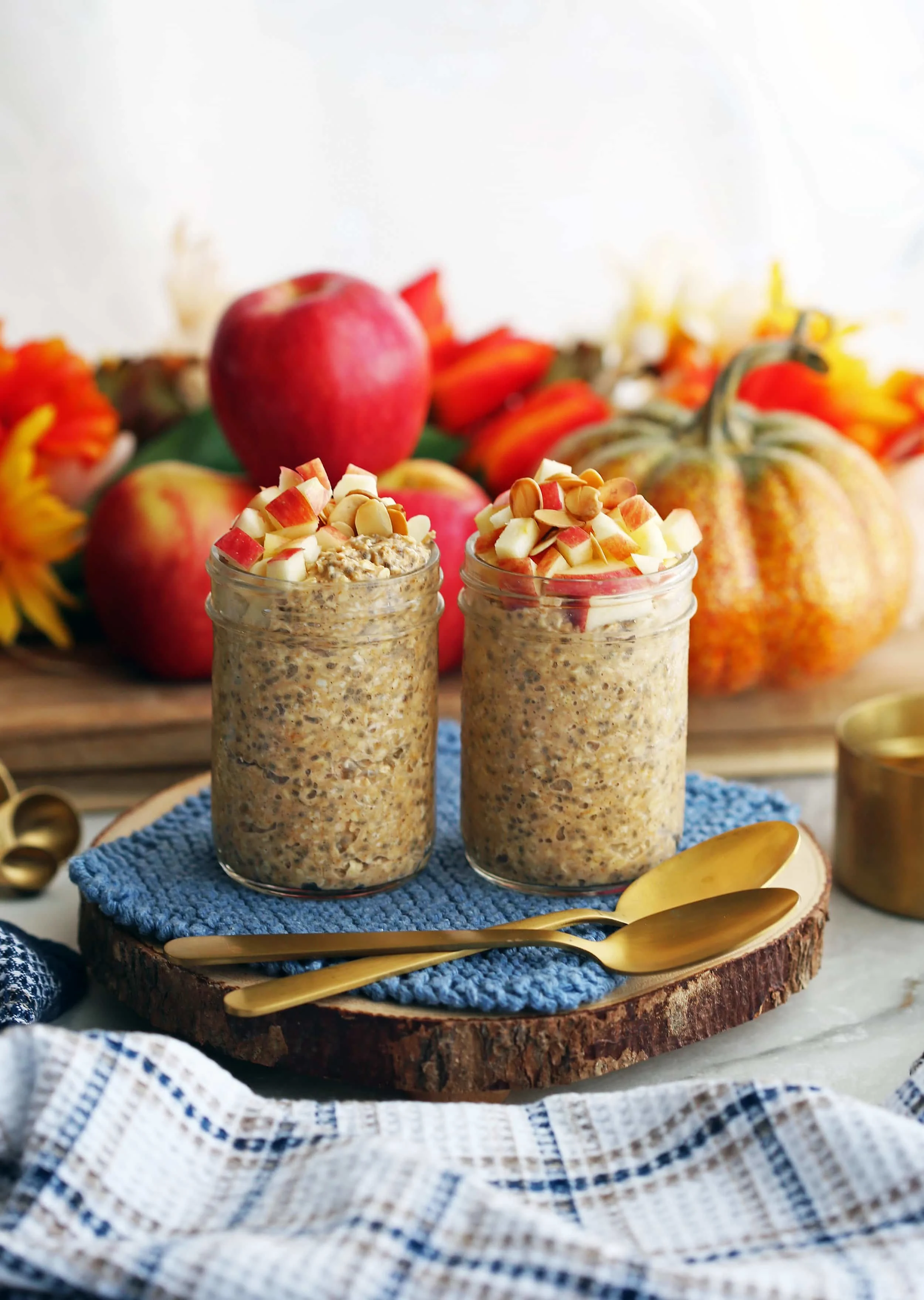 Chai spiced pumpkin overnight oats topped with diced apples and slivered in two mason jars.