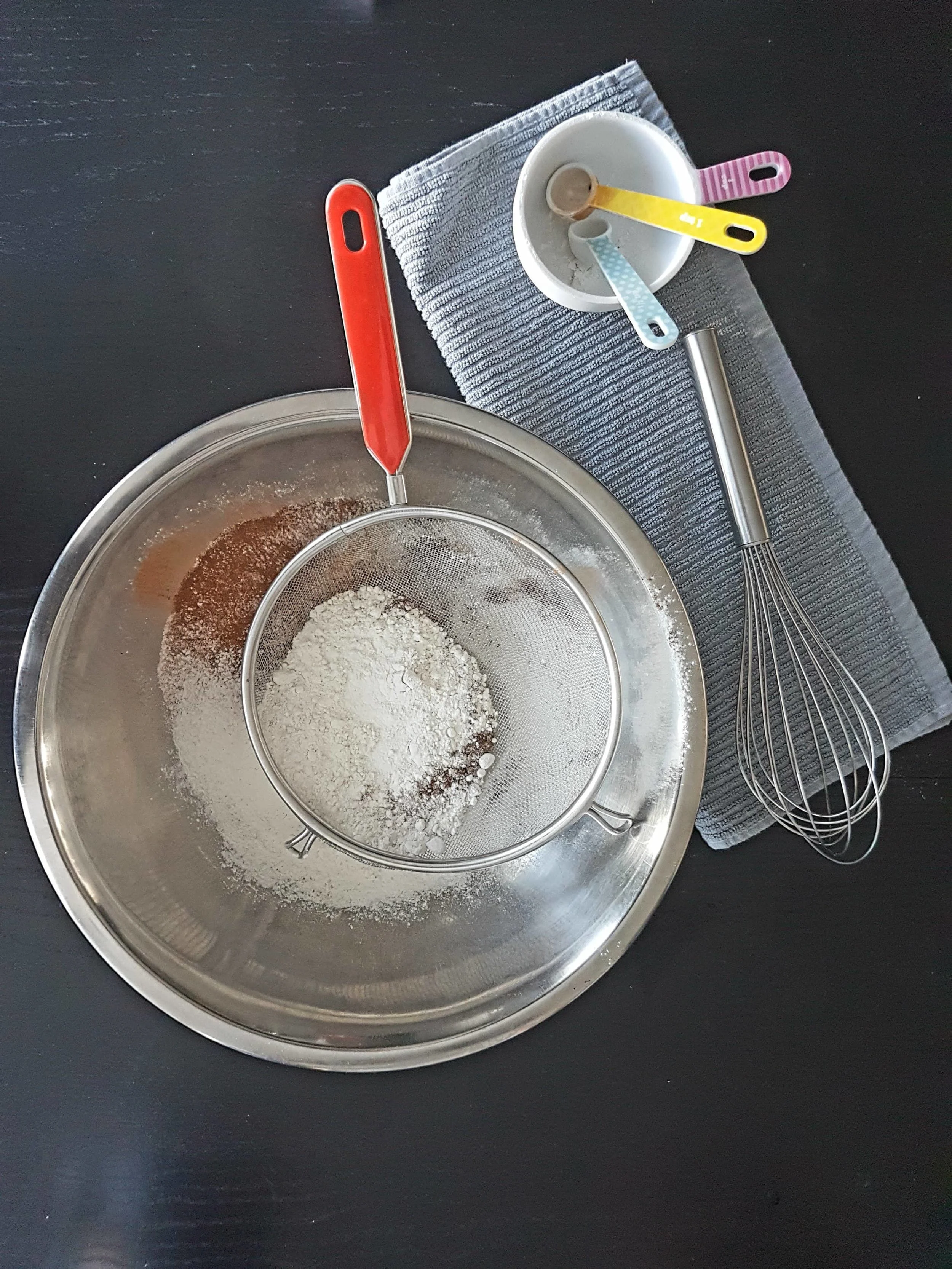 Dry ingredients being sifted into a bowl.