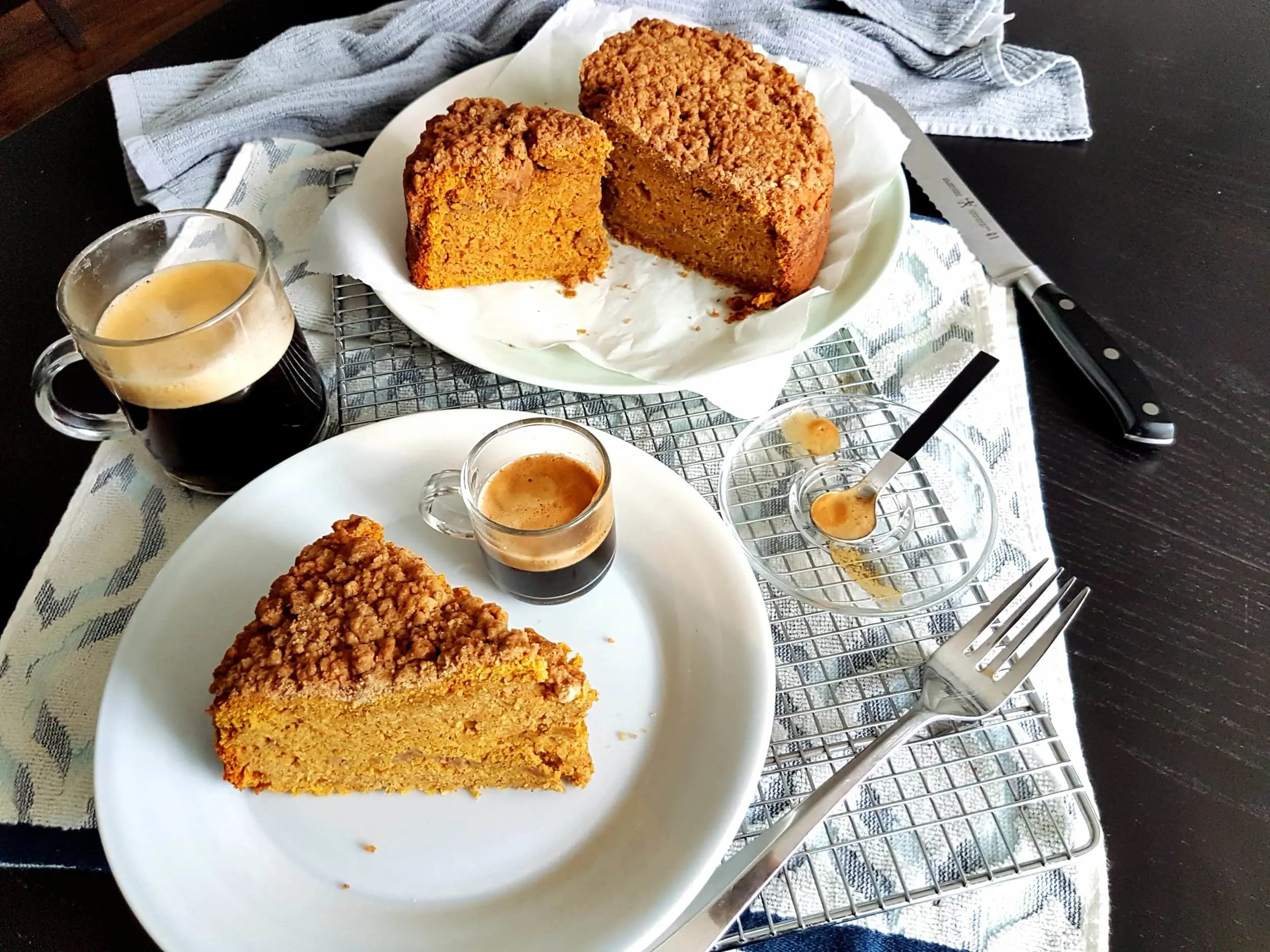 A slice of Pumpkin Sour Cream Coffee Cake with a cup of coffee.