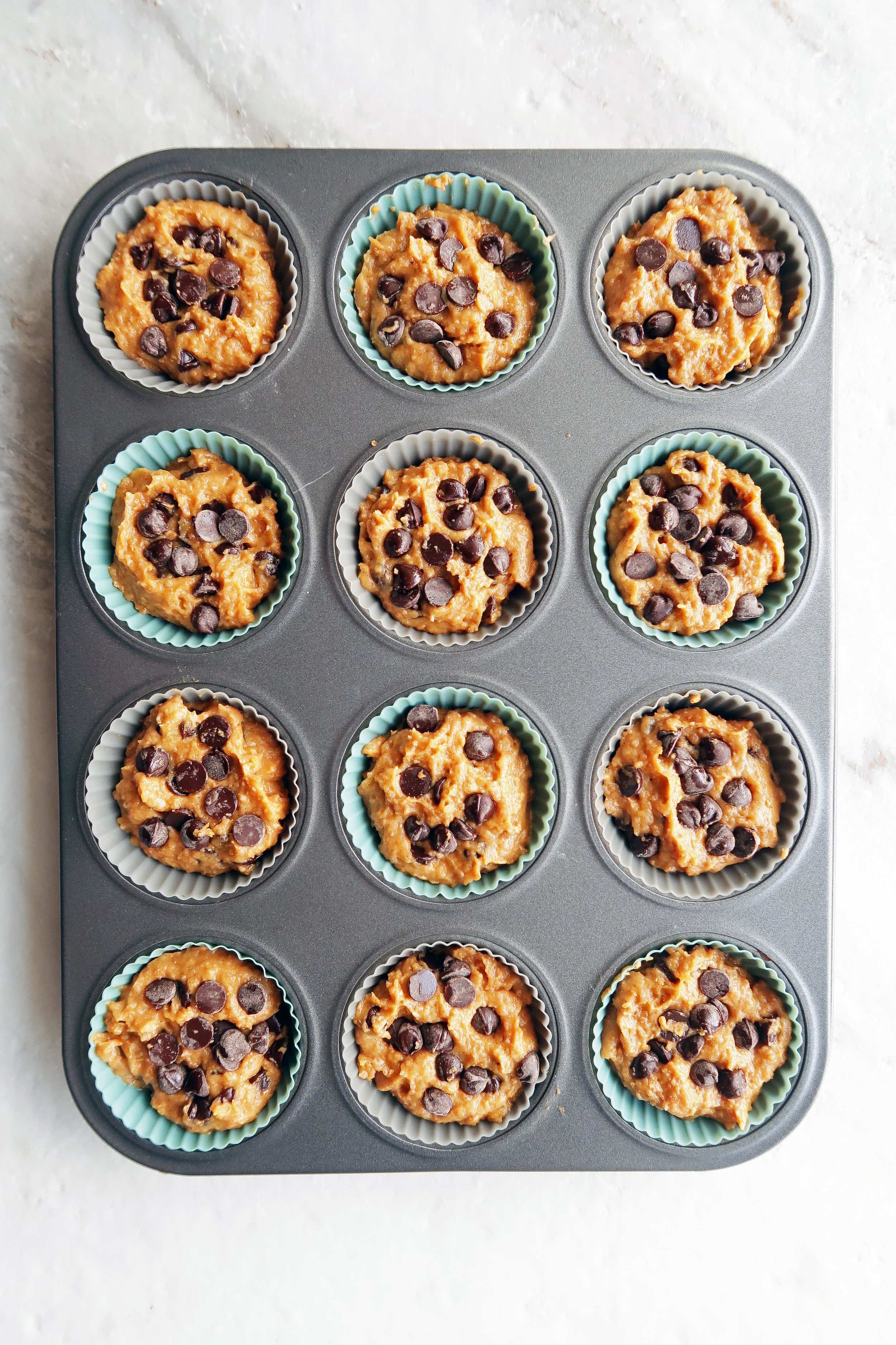 Pumpkin chocolate chip whole wheat muffin batter scooped evenly into a 12 cup muffin pan.