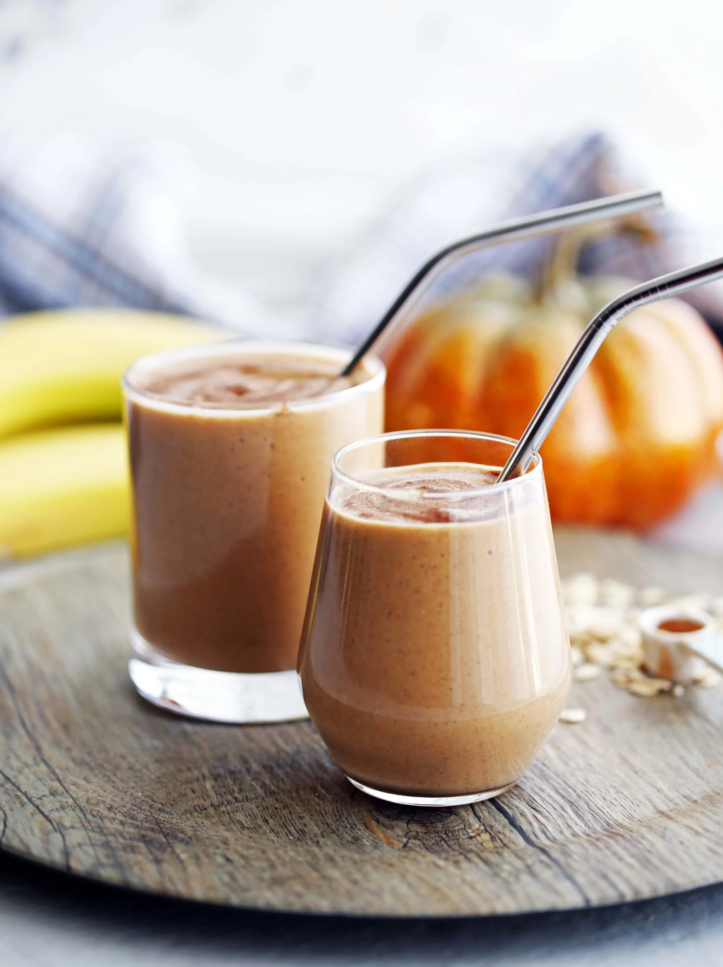 Side view of two glasses of pumpkin pie spice protein smoothies.