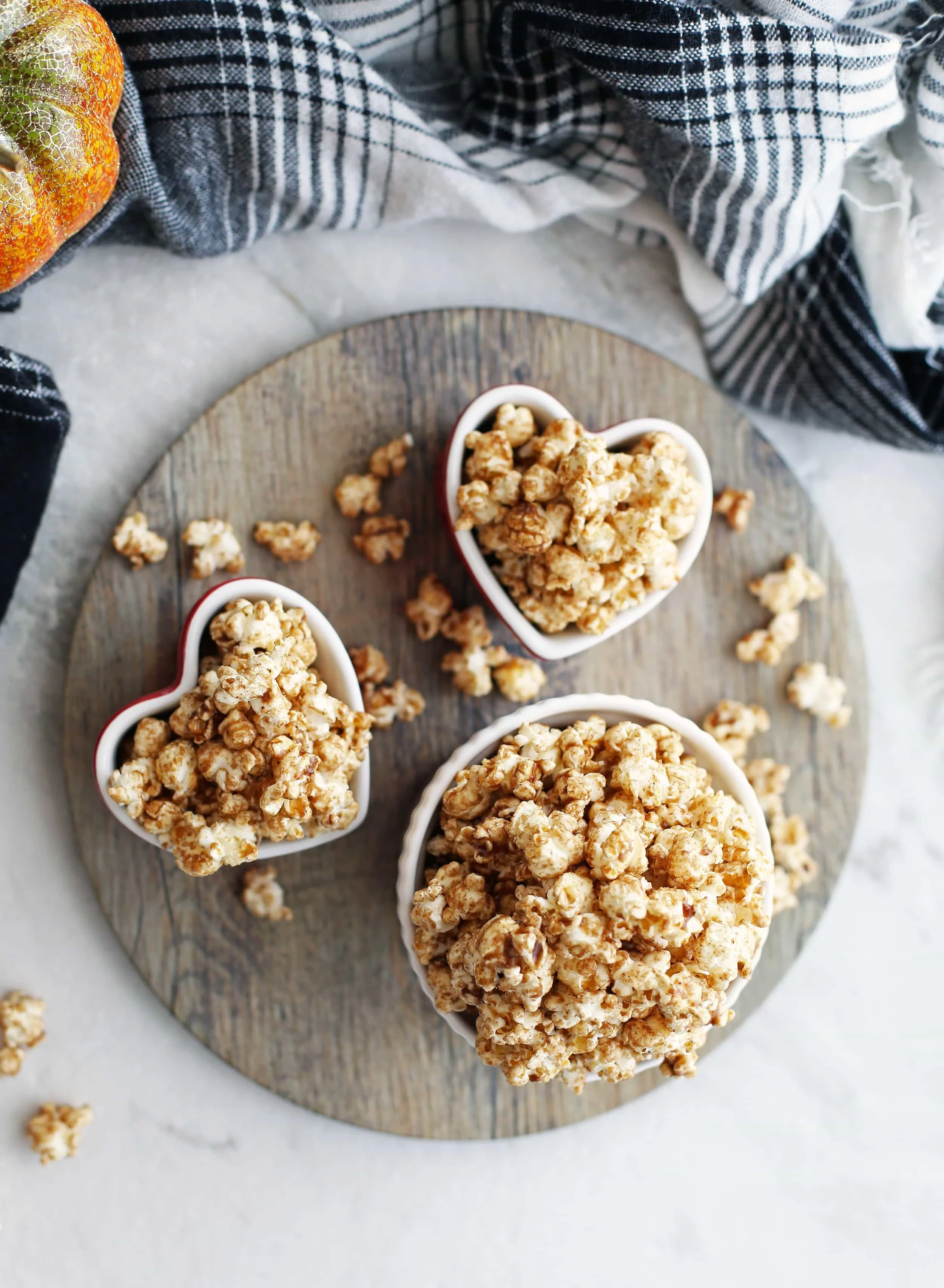 Overhead view of homemade pumpkin spice butterscotch popcorn in three bowls.