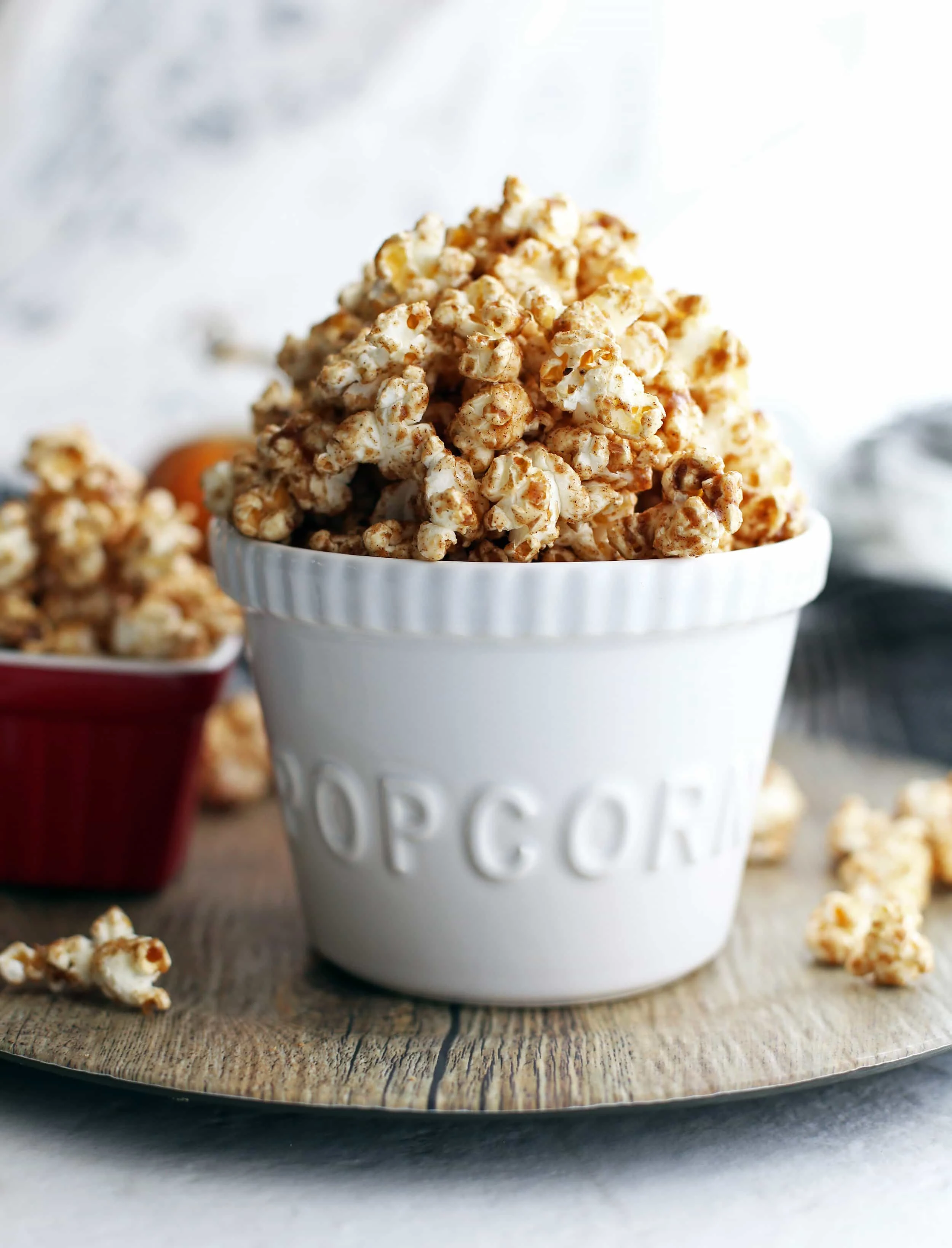 Close-up side view of homemade pumpkin spice butterscotch popcorn in a white bowl.