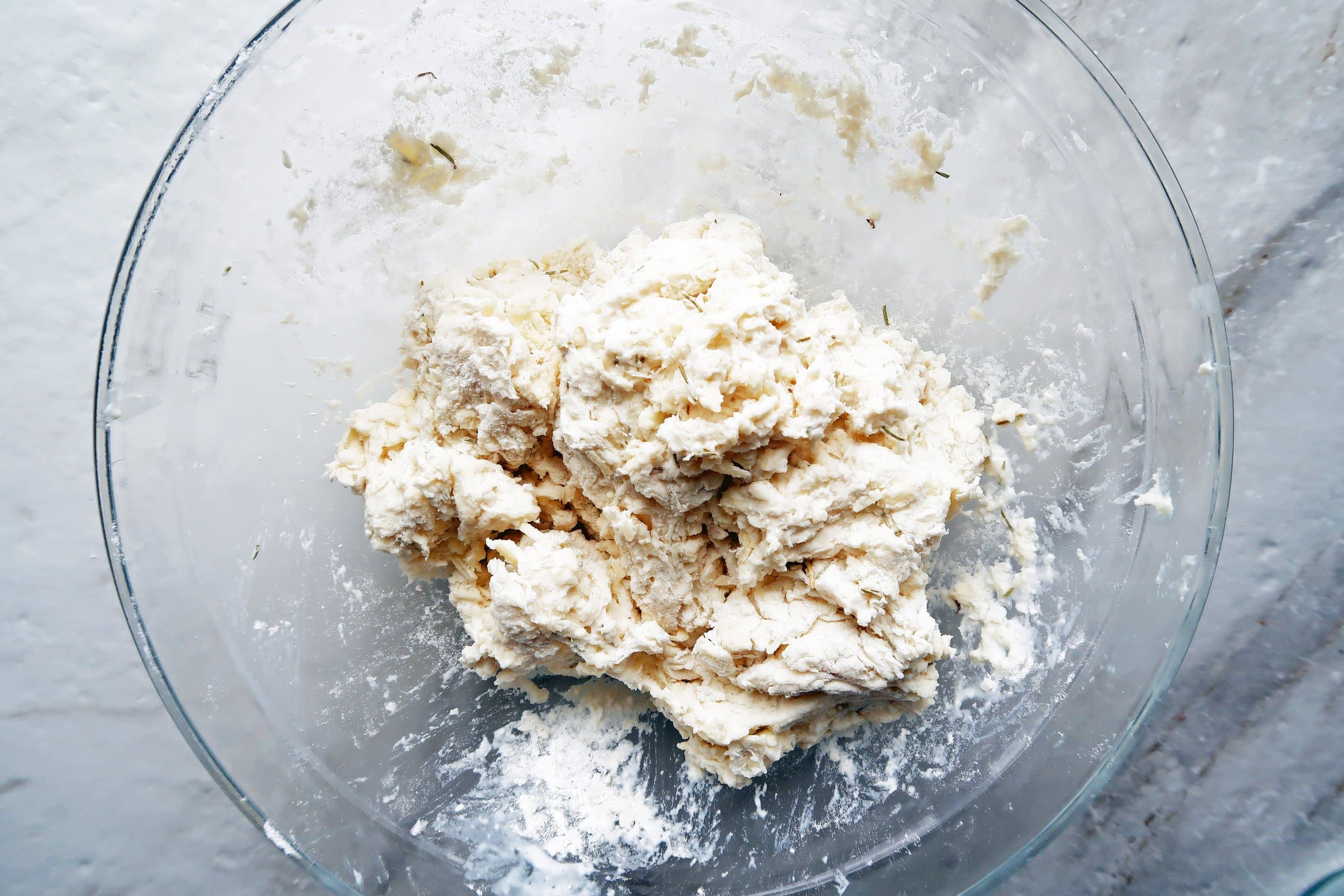 Rosemary Cheddar Drop Biscuit dough in a large glass bowl.