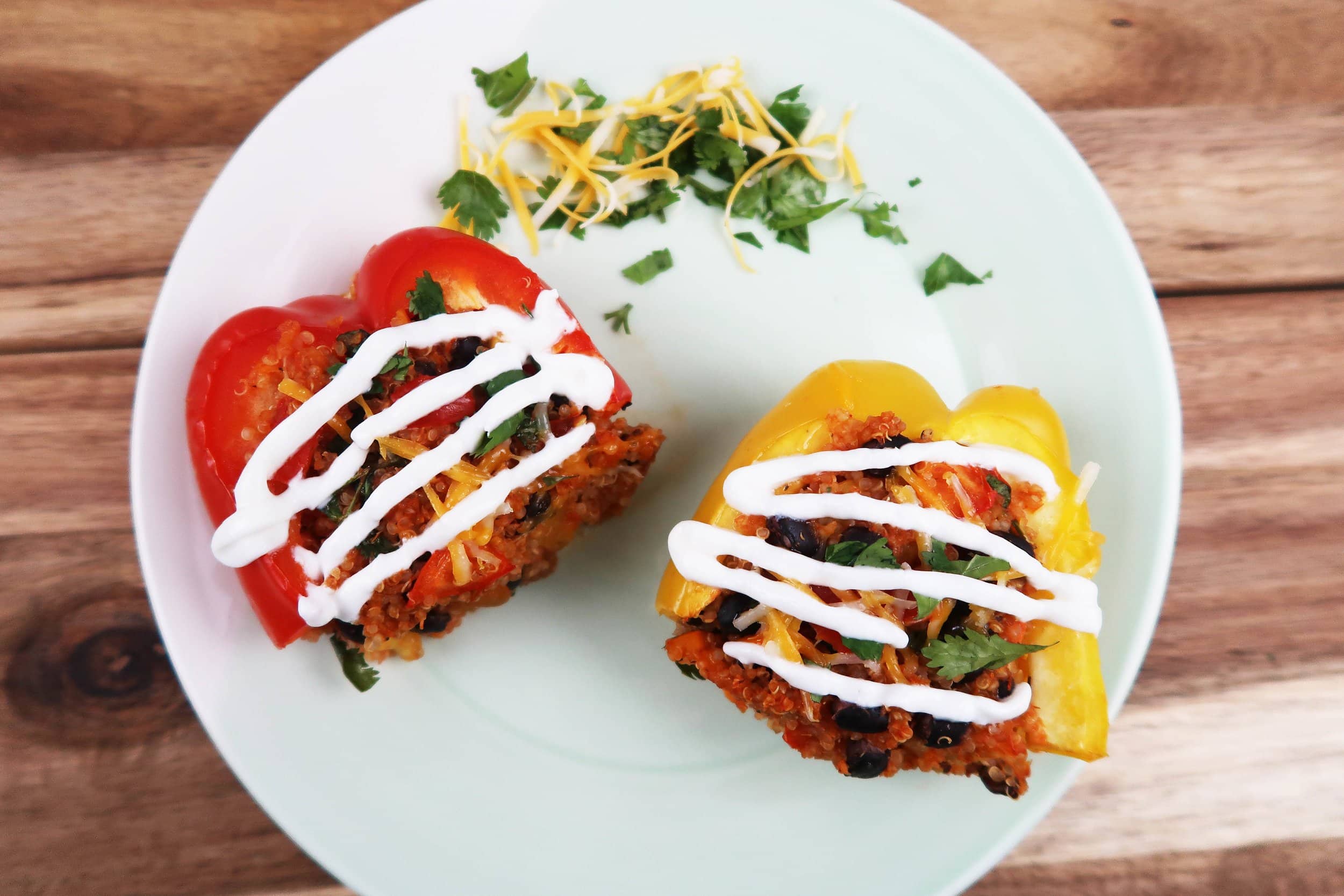 Quinoa and Black Bean Stuffed Bell Peppers on a plate with sour cream.