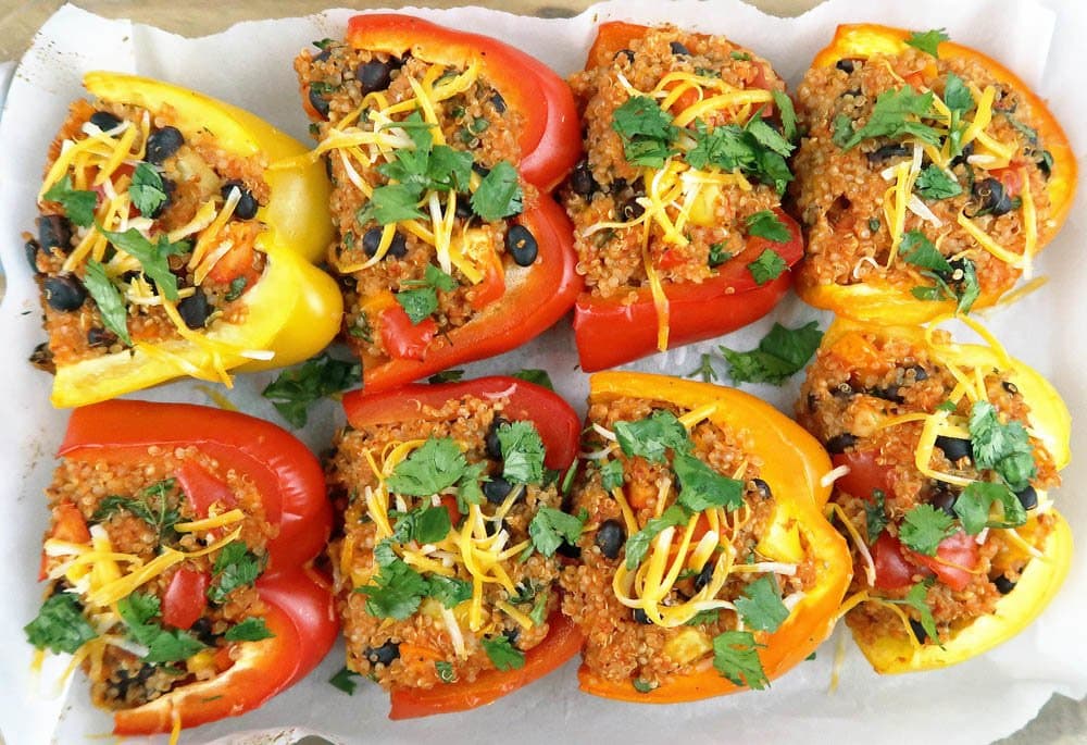 Quinoa and Black Bean Stuffed Bell Peppers topped with cheese and cilantro.