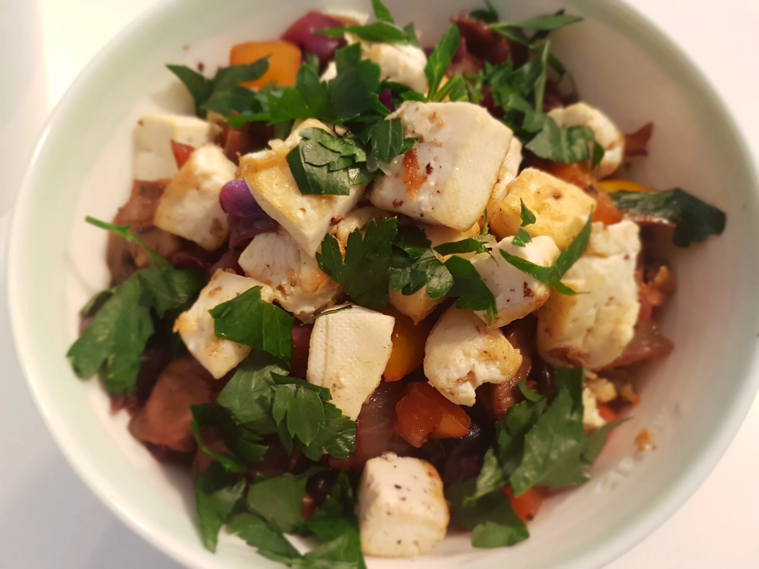 An overhead close-up of Quinoa with Fresh Vegetables and Tofu in a bowl.