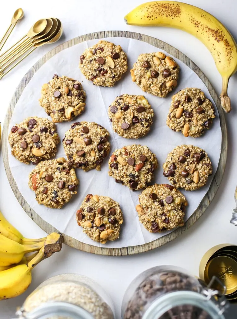 Overhead view of trail mix cookies on a round wooden platter.