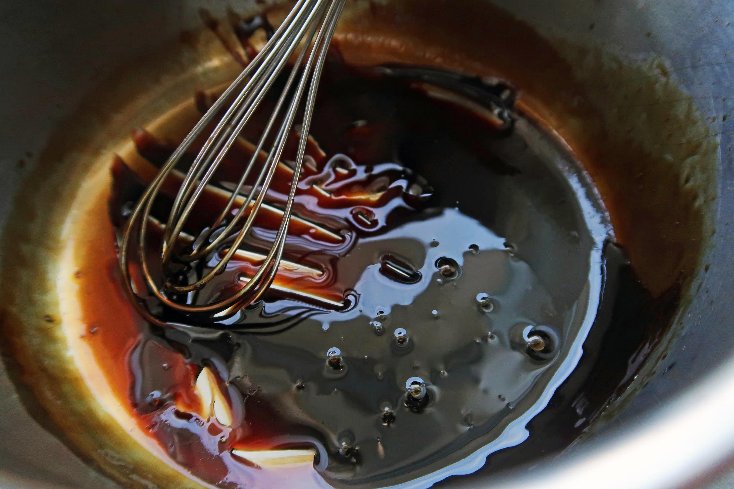 A saucepan containing a balsamic vinegar and maple syrup glaze.