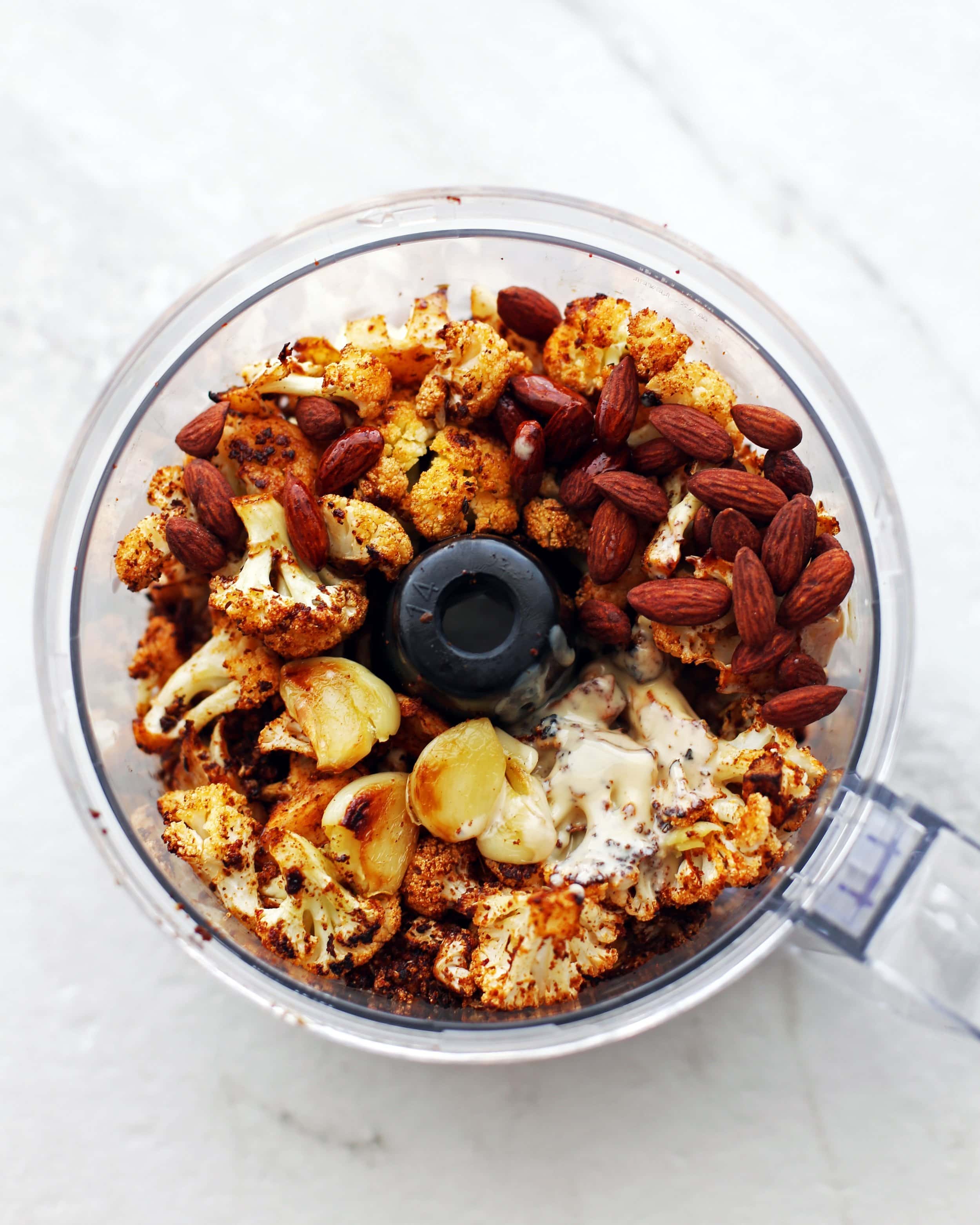 Roasted spiced cauliflower, roasted garlic, tahini, roasted almonds, olive oil, and lemon juice in a food processor.