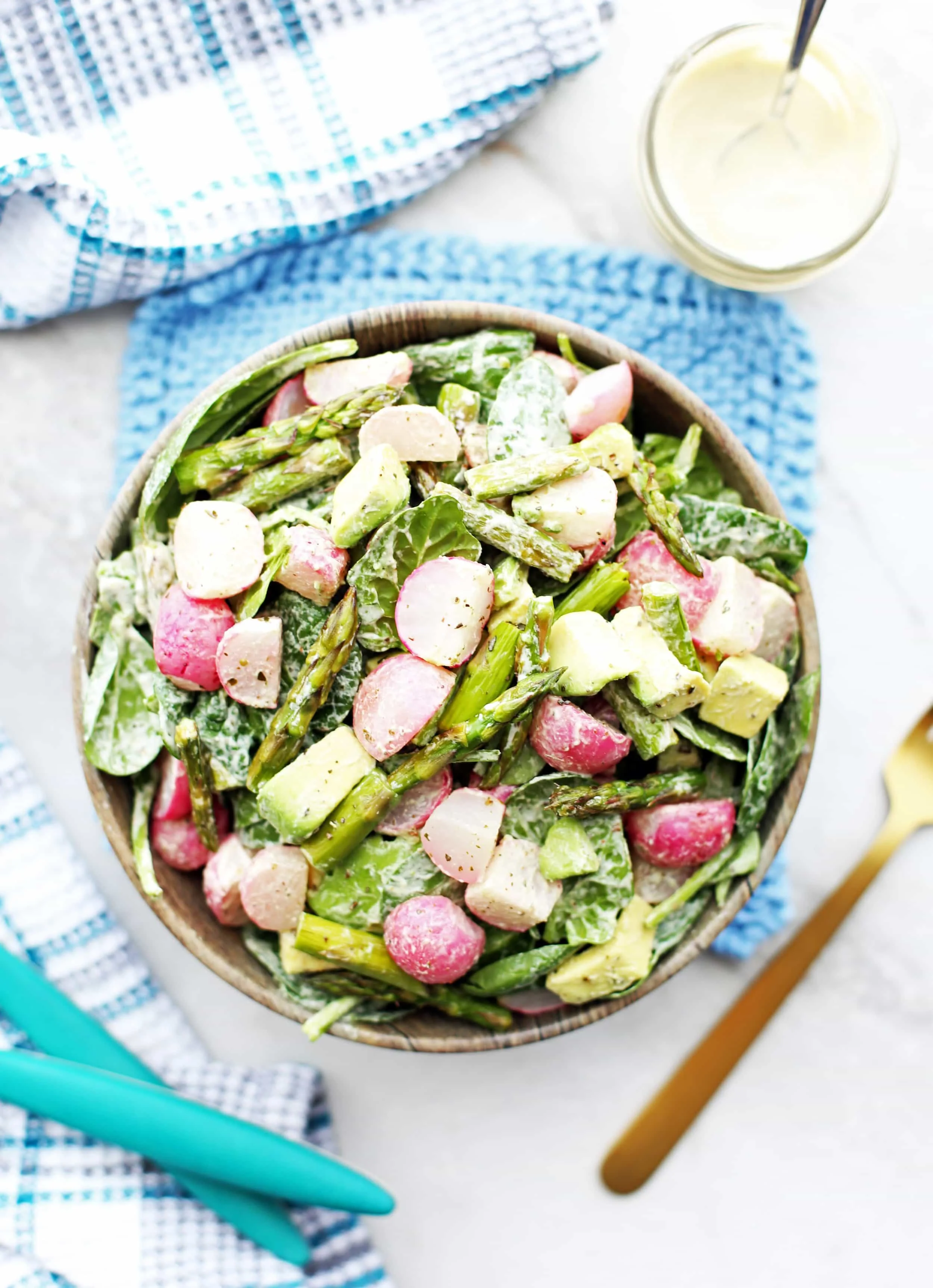 Overhead Roasted Asparagus and Radish Salad with Creamy Garlic Cashew Dressing in a wooden bowl.