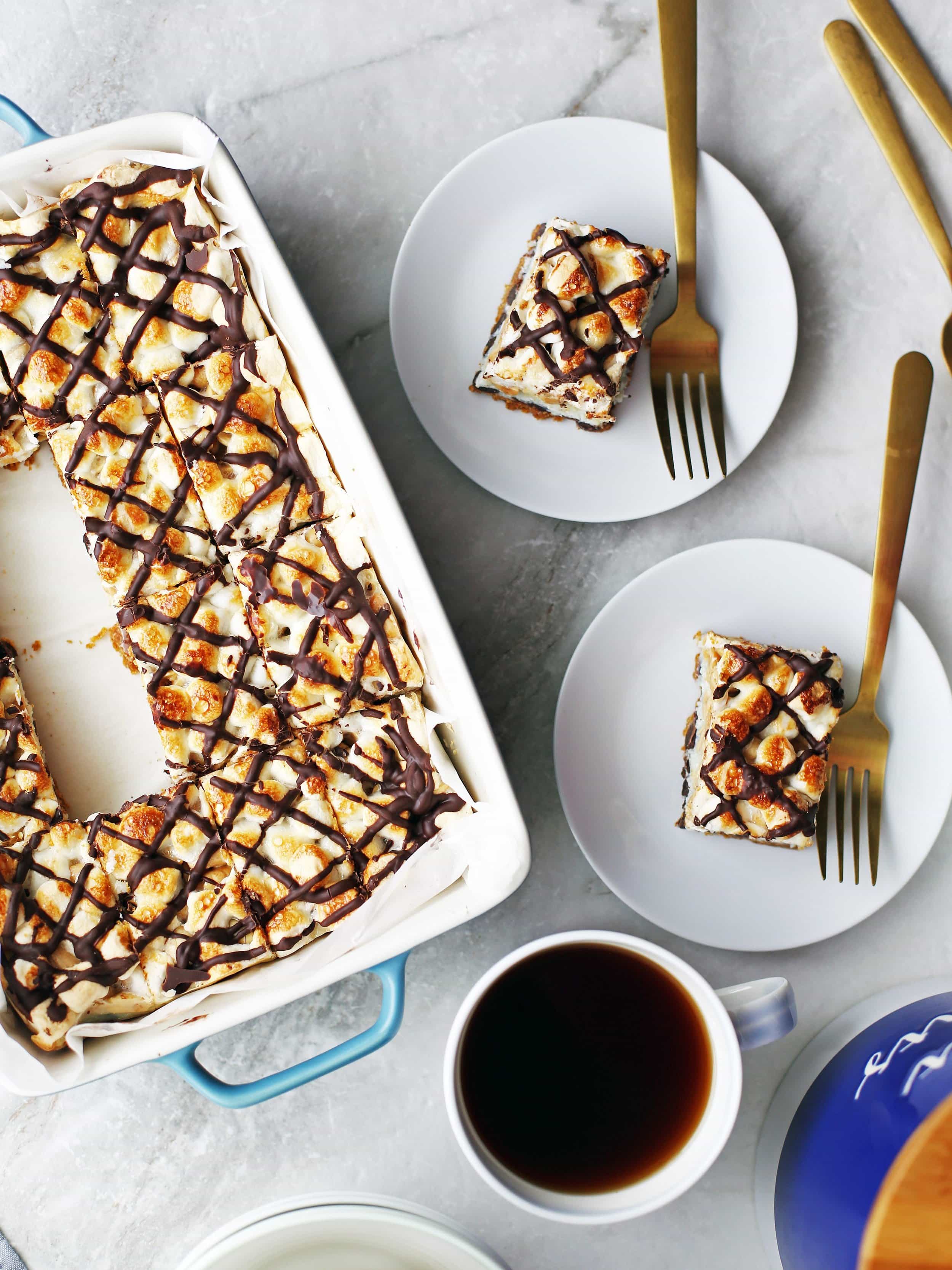 Overhead shot of two plates with a piece of rocky road magic on each along with sliced bars in a baking dish.