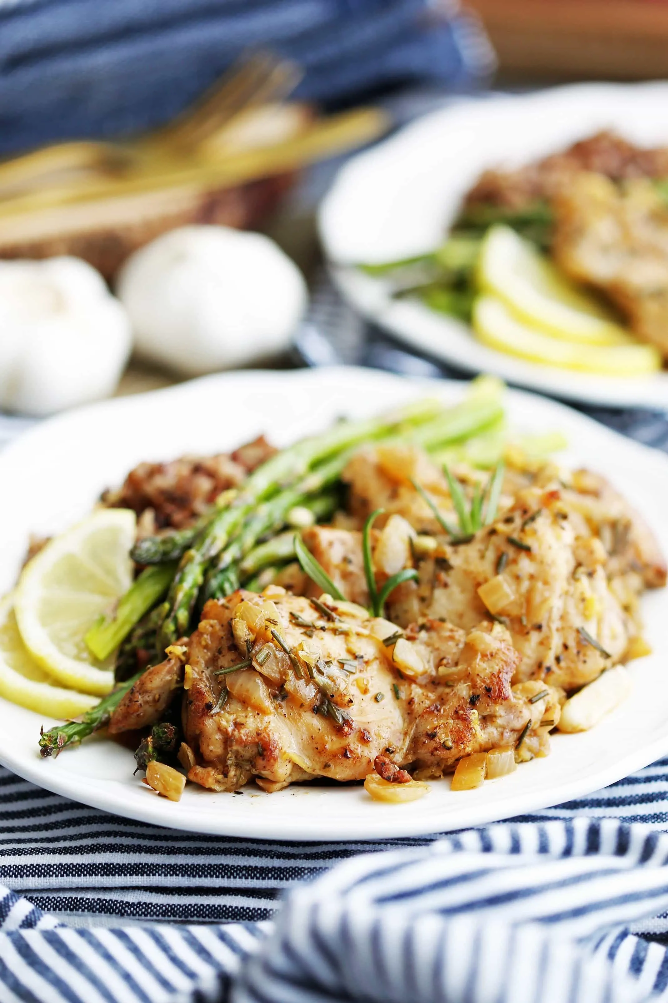 Rosemary garlic chicken, roasted asparagus, and wild rice on a white plate.