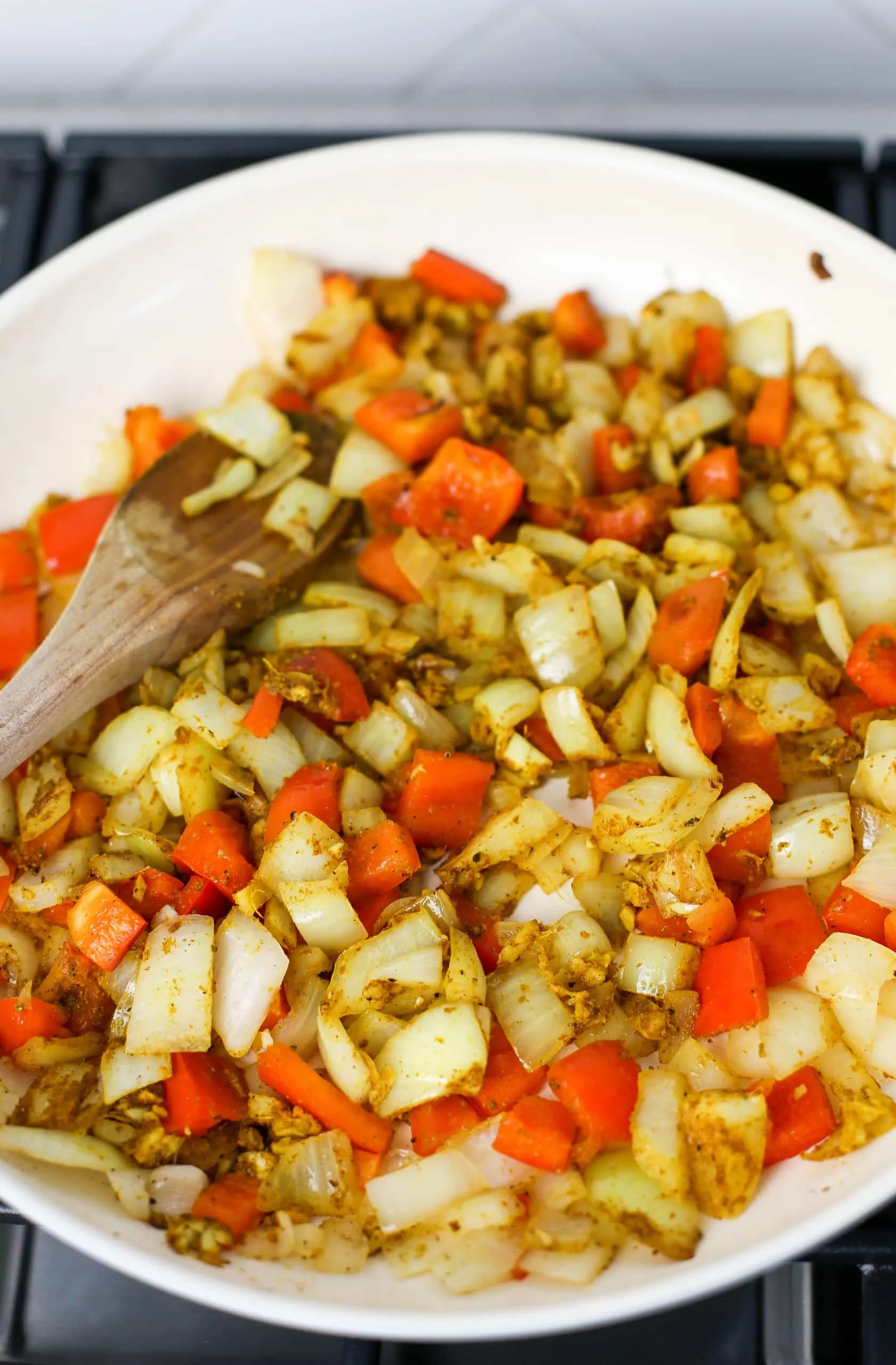 Sautéed onions, peppers, garlic, ginger, and spices in a large skillet.