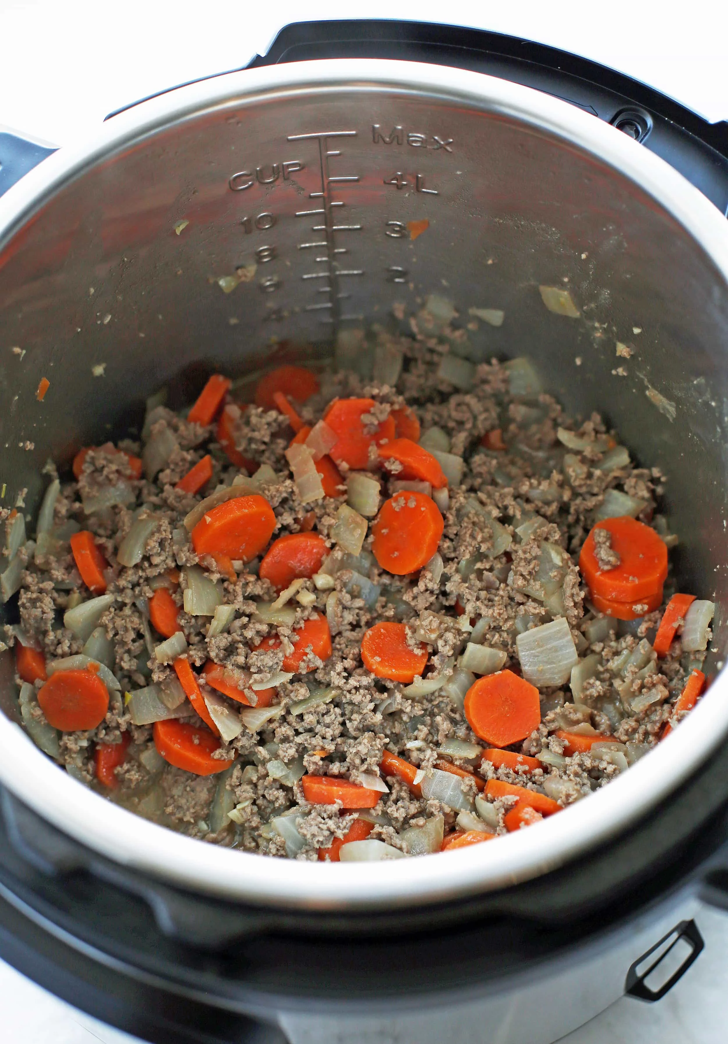 Sautéed onions, carrots and ground beef in the Instant Pot.