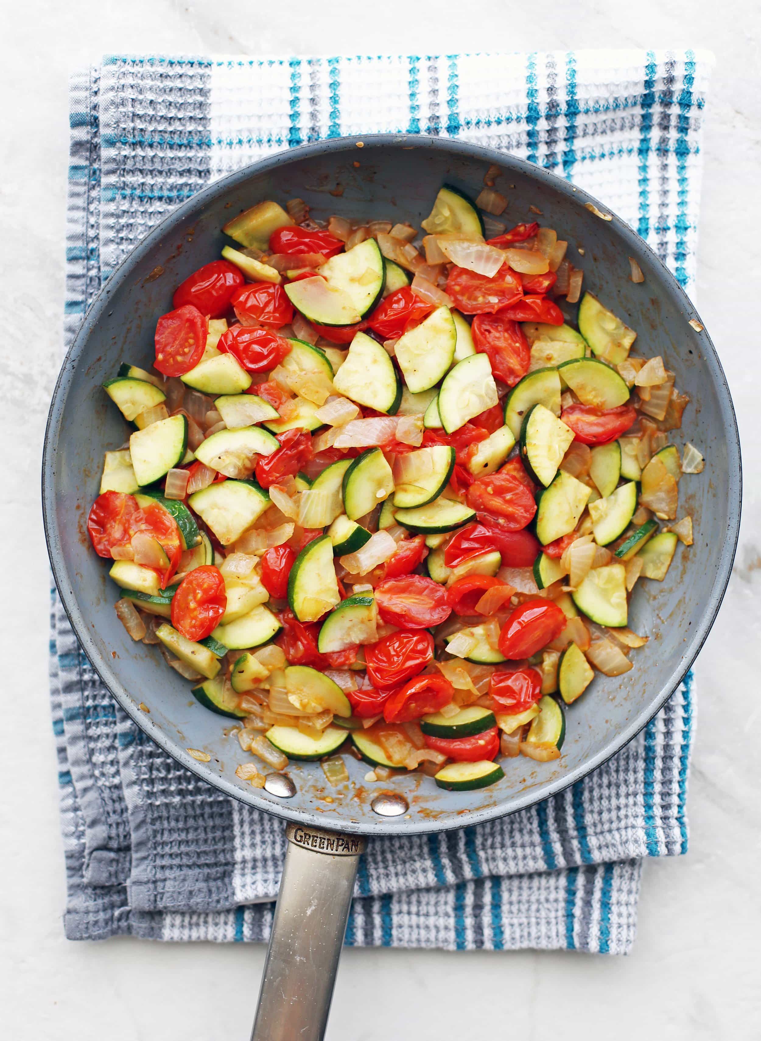 Quick sautéed onions, green zucchini, and tomatoes in a large skillet.