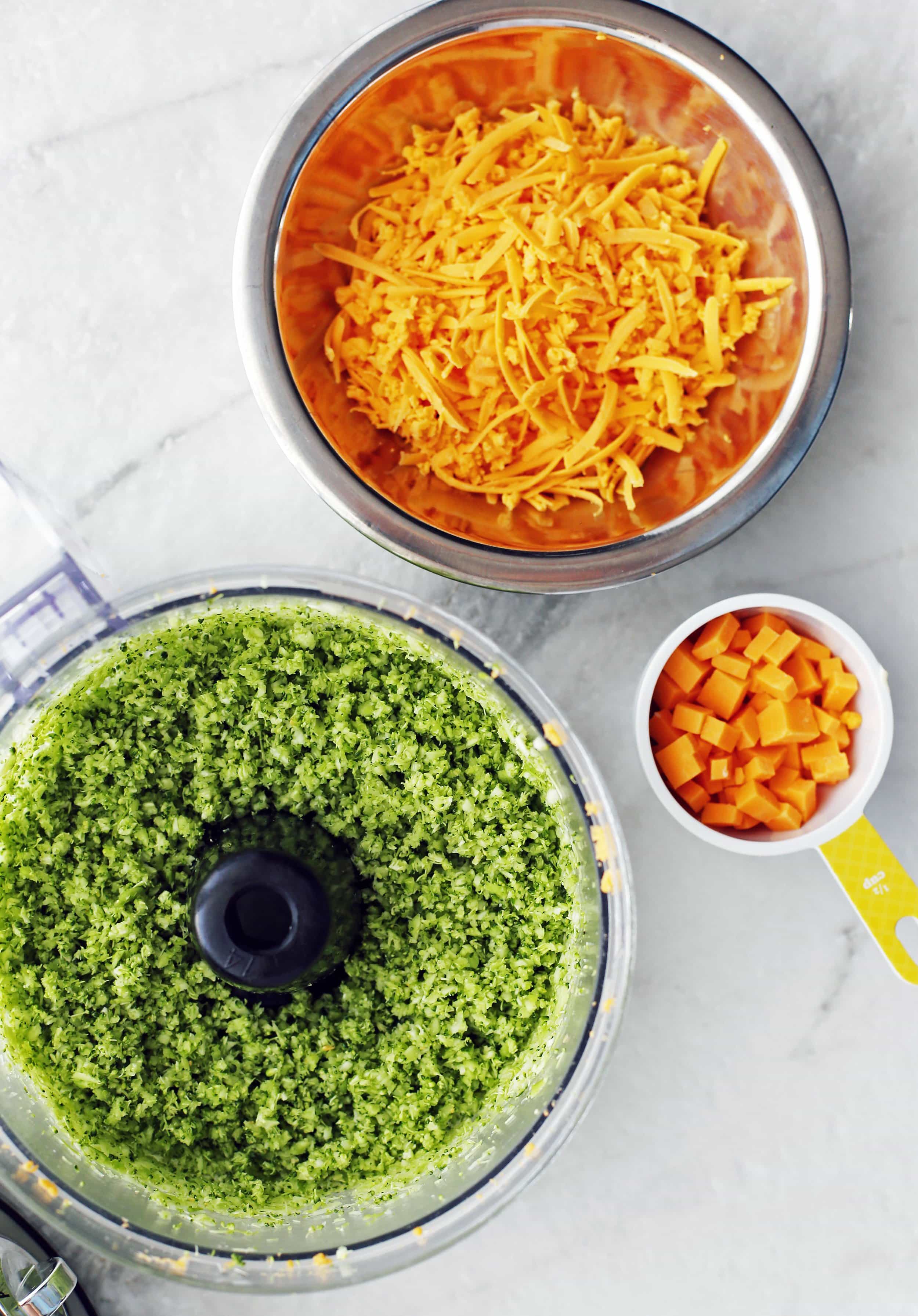 Shredded cheddar cheese, diced cheddar cheese, and finely diced broccoli in bowls.