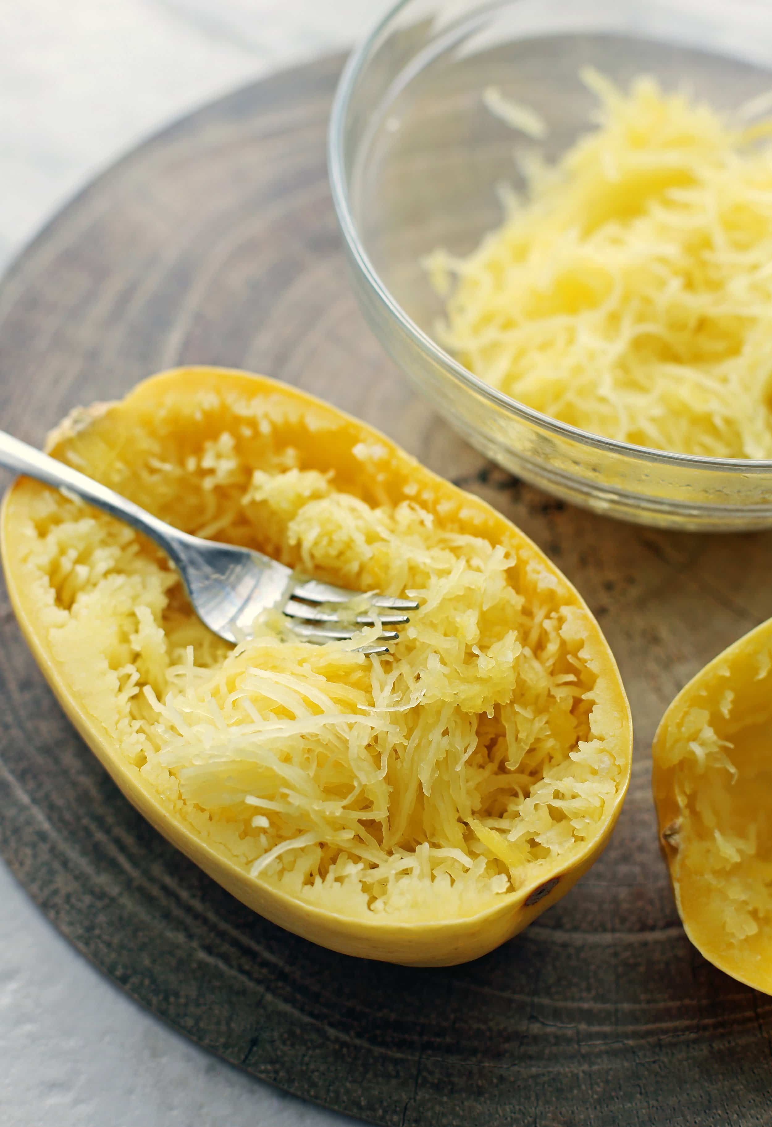 Spaghetti squash strands in a halved squash shell that has been removed with a fork.