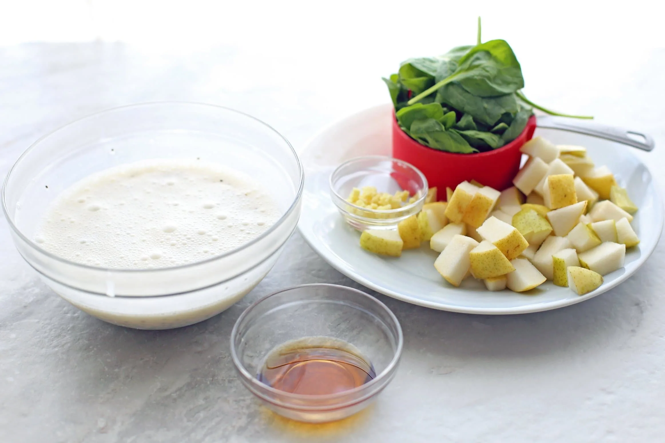 Chopped up pears and ginger, spinach, and almond milk with chia seeds in it.