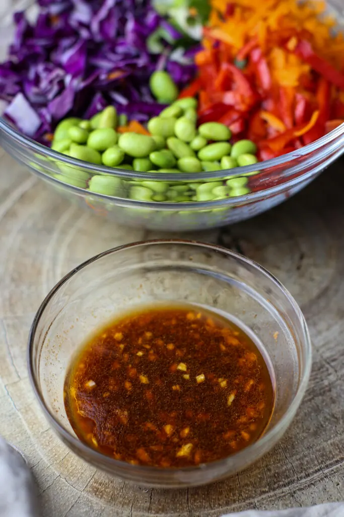 A small glass bowl containing soy sauce, minced garlic