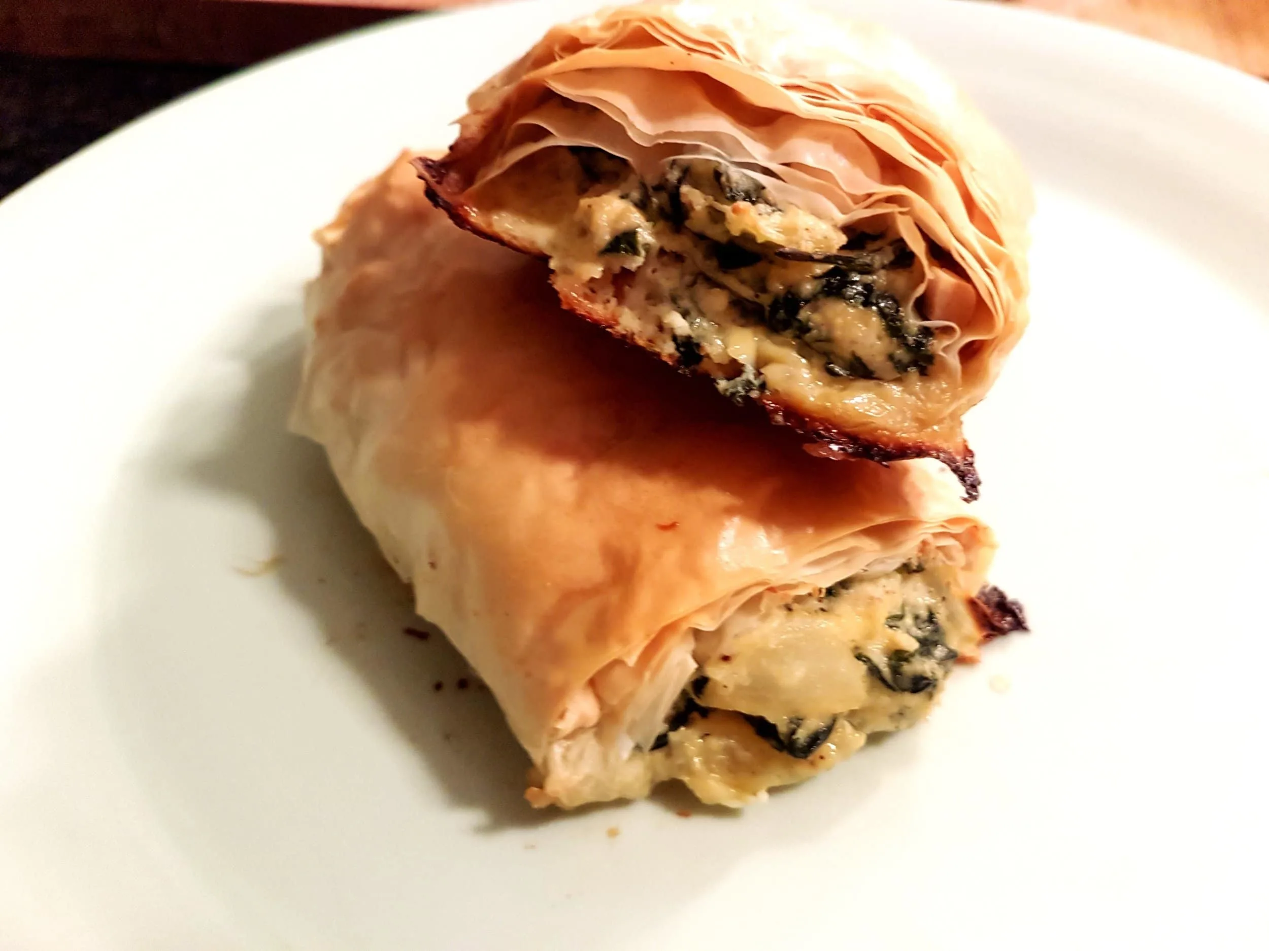 Two Spanakopita Rolls stacked on top of each other.