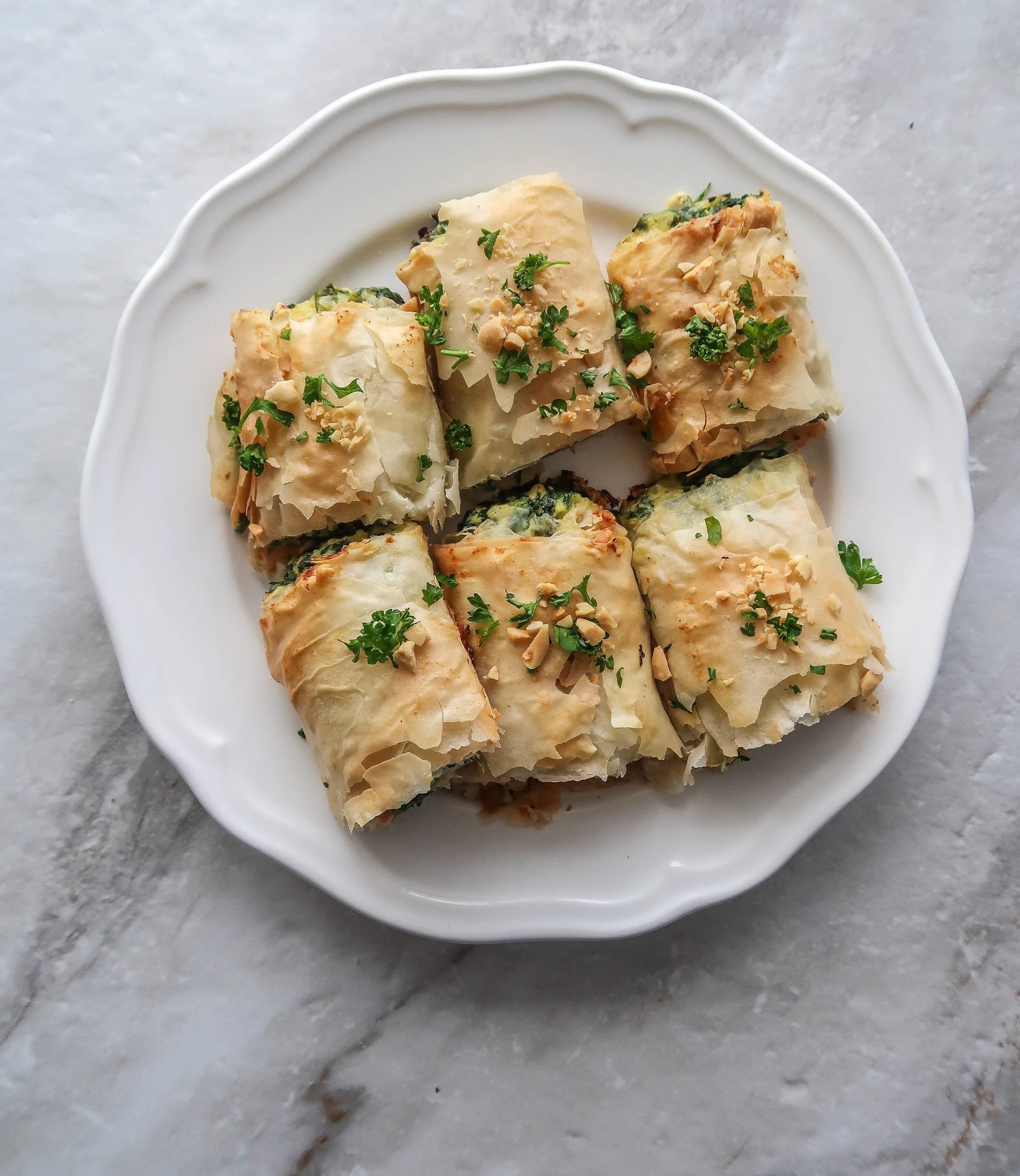 A plate with six Spinach and Ricotta Spanakopita Roll halves.