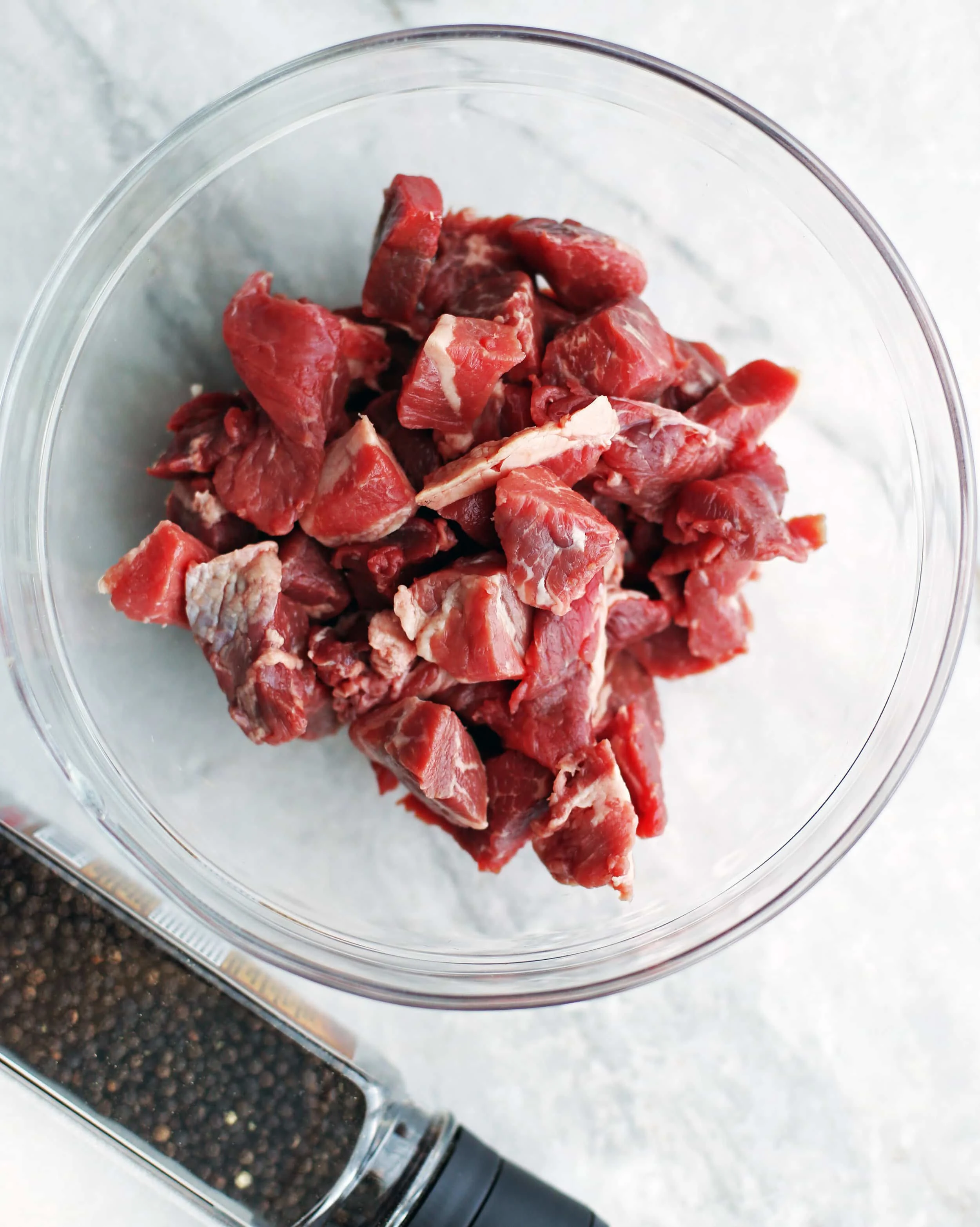 Small pieces of stew beef in a glass bowl.