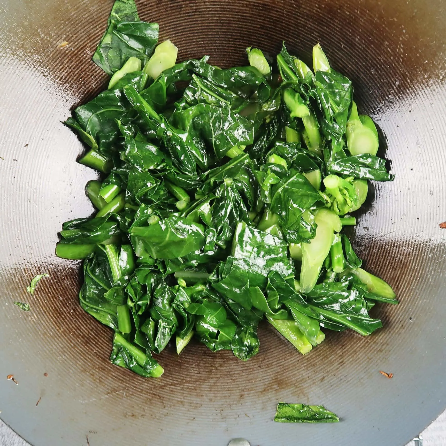 Sauteed sliced gai lan (Chinese broccoli) in the wok.