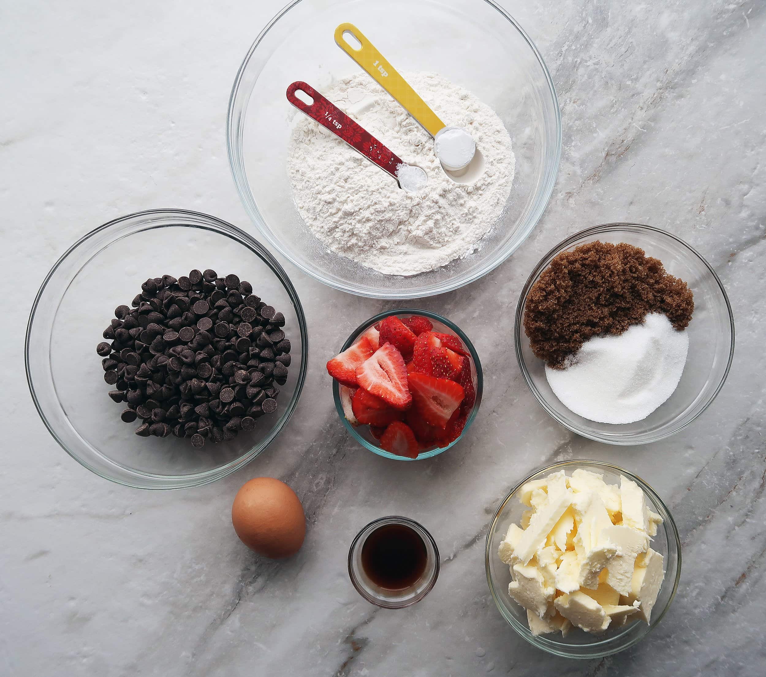 Chocolate chips, strawberries, flour, sugar, an egg, butter, and vanilla.