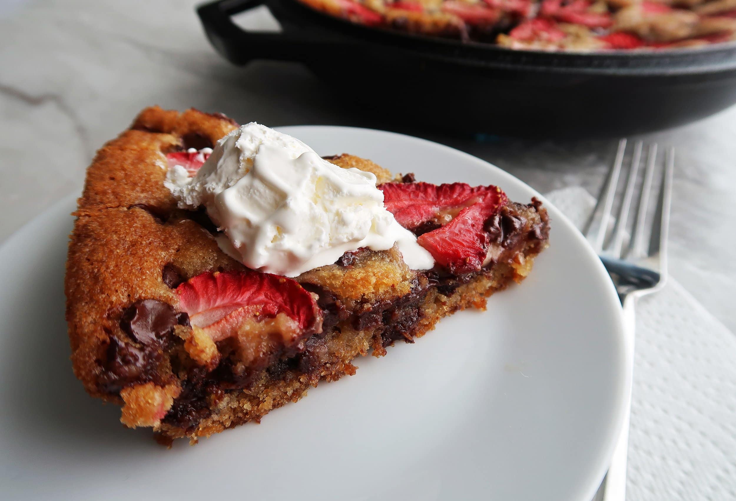 A slice of Strawberry Chocolate Chip Skillet Cookie on a plate.