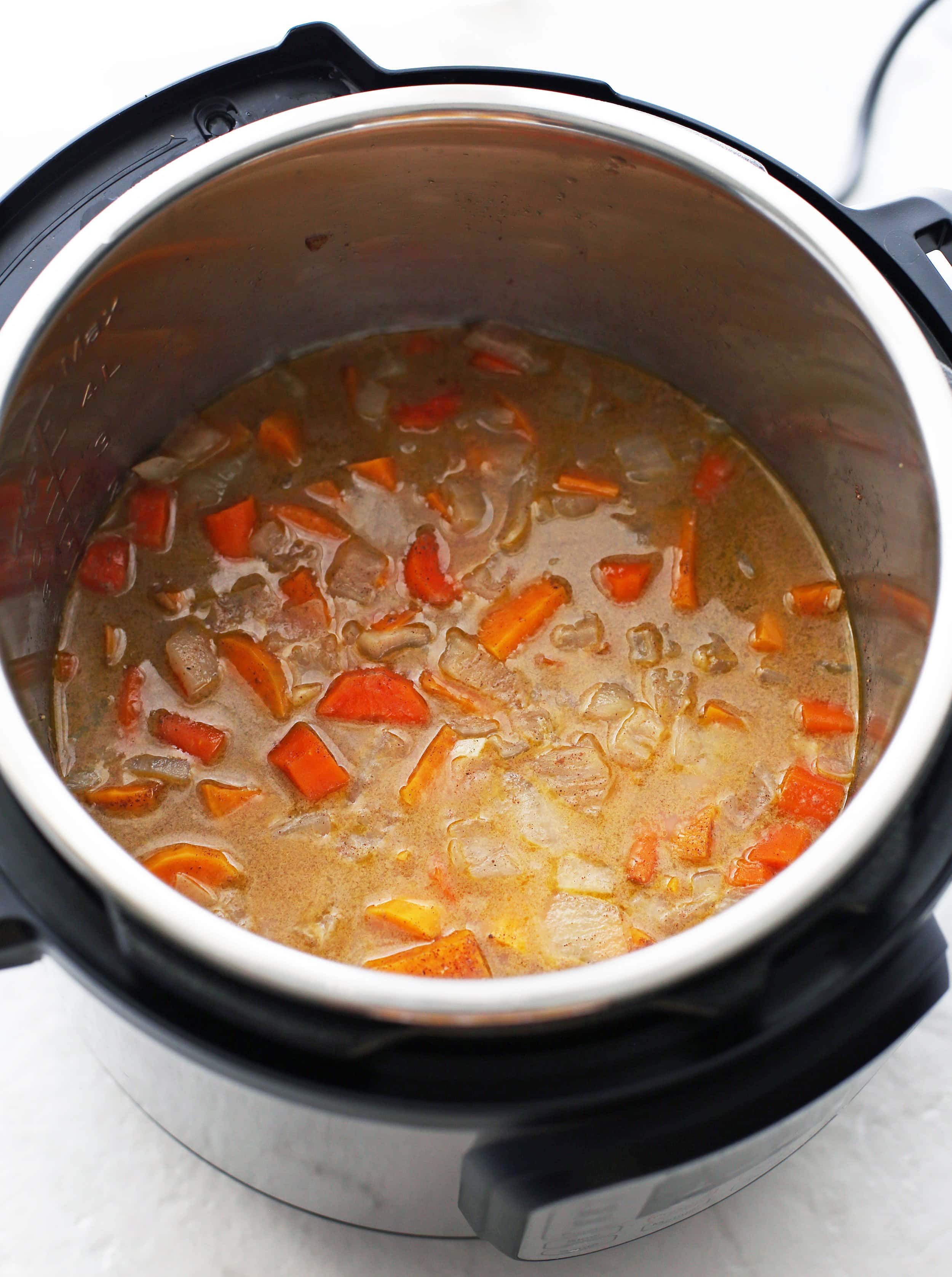 Sautéed onions, garlic, ginger, sweet potato, carrots, coconut milk, and spices in cooked in the Instant Pot.