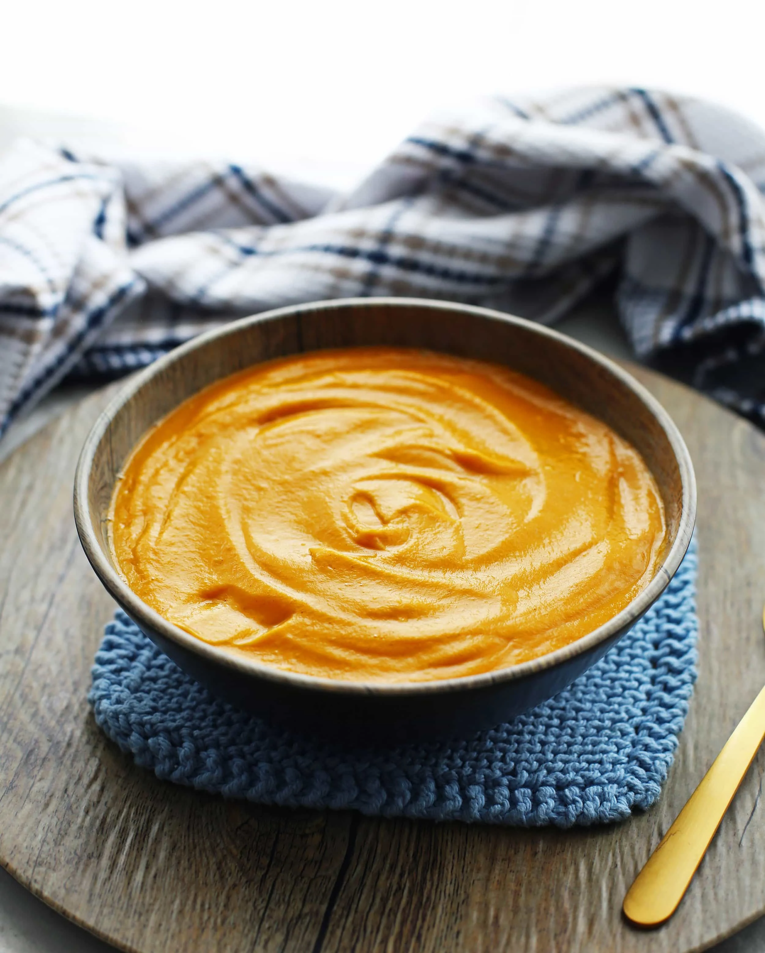 Creamy orange Instant Pot sweet potato coconut soup in a wooden bowl.