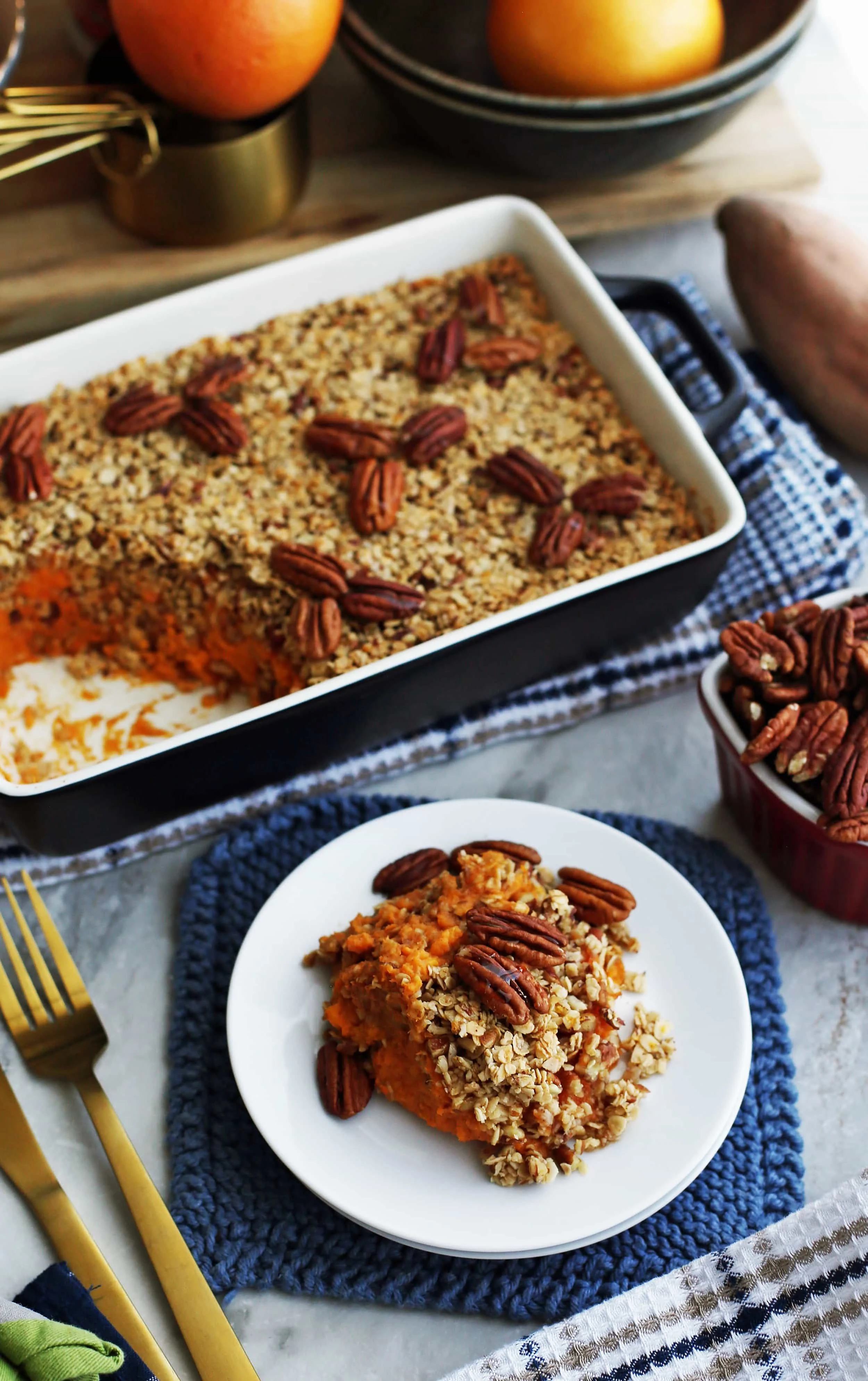 Sweet Potato Mash with Pecan Oat Topping on a white plate and in a black casserole dish.