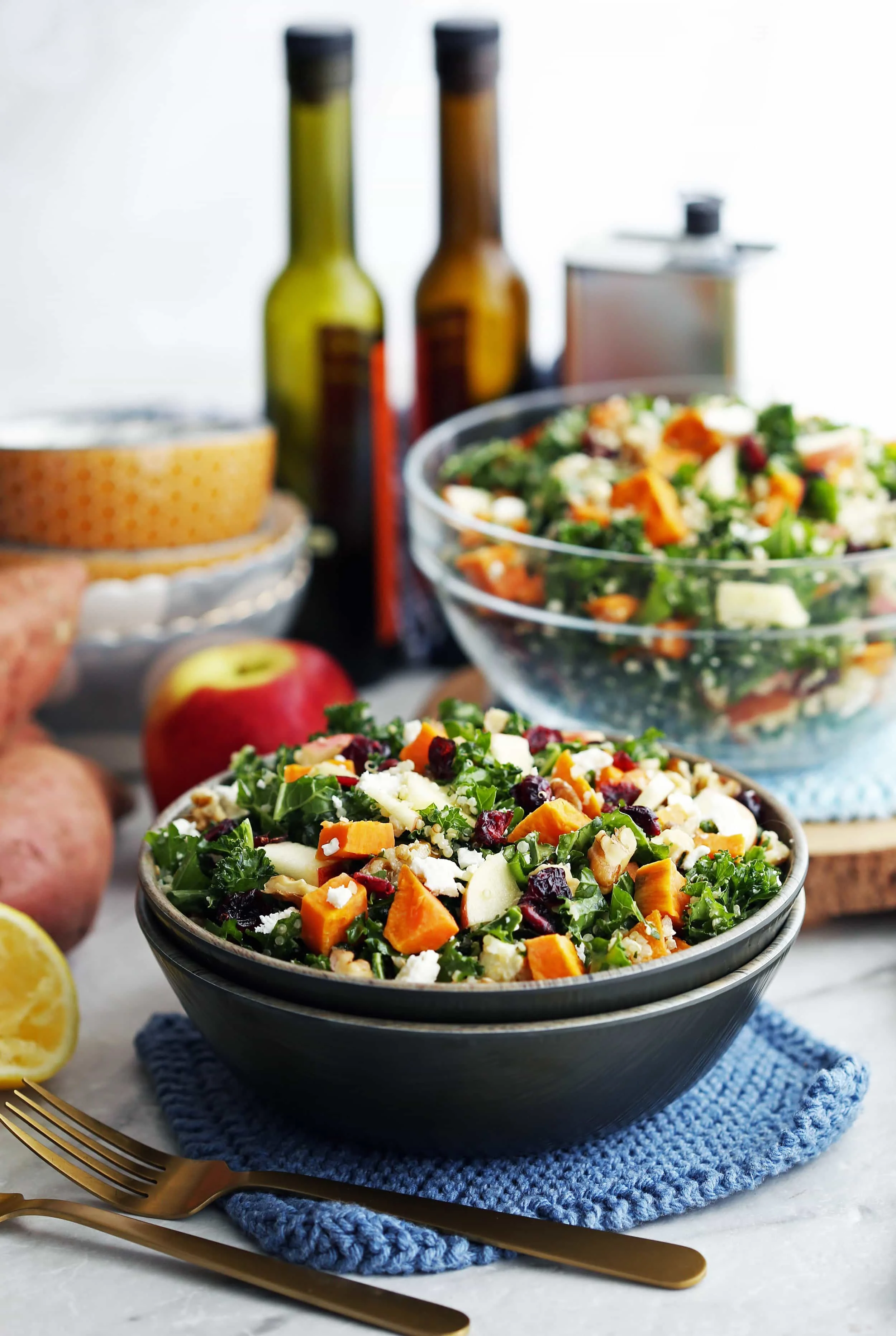 Roasted sweet potato quinoa kale salad in a wooden bowl and a glass bowl.