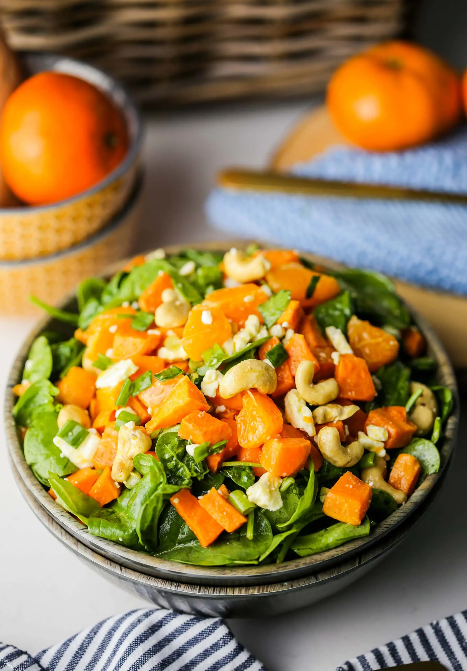Sweet potato orange spinach salad in a wooden bowl.