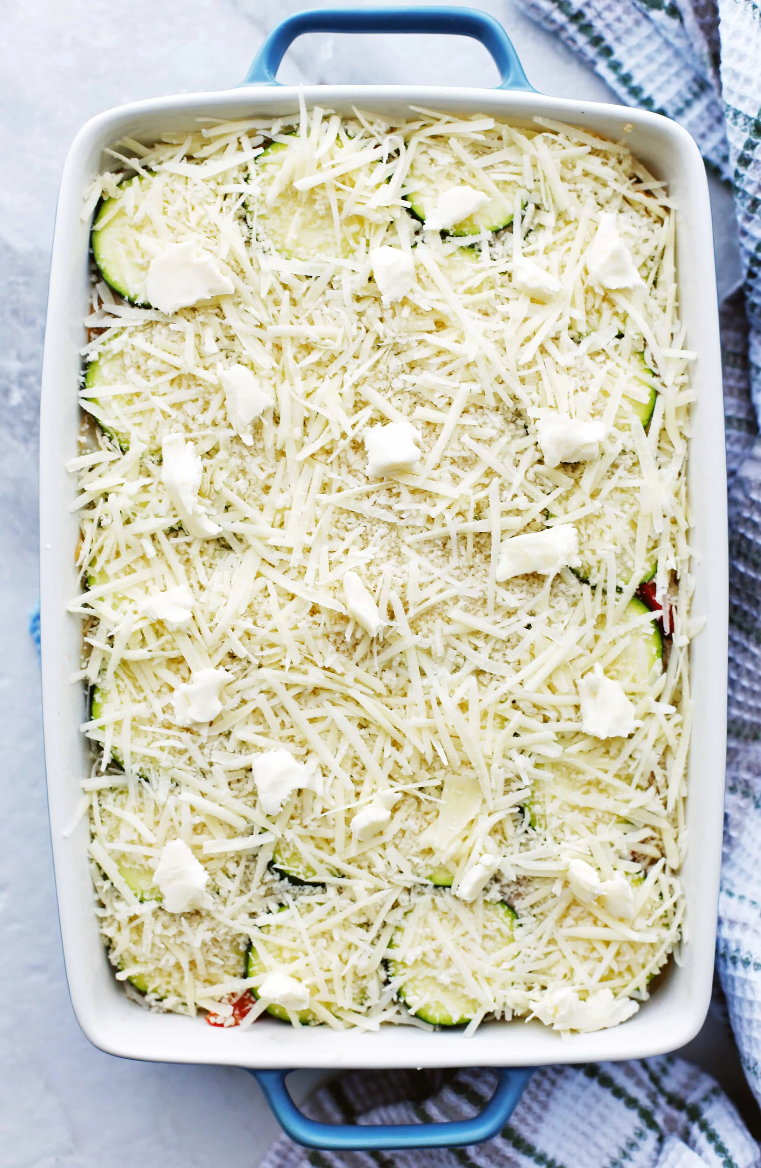Unbaked Zucchini Gratin with Gruyère and Panko Breadcrumbs in a large rectangular casserole dish.