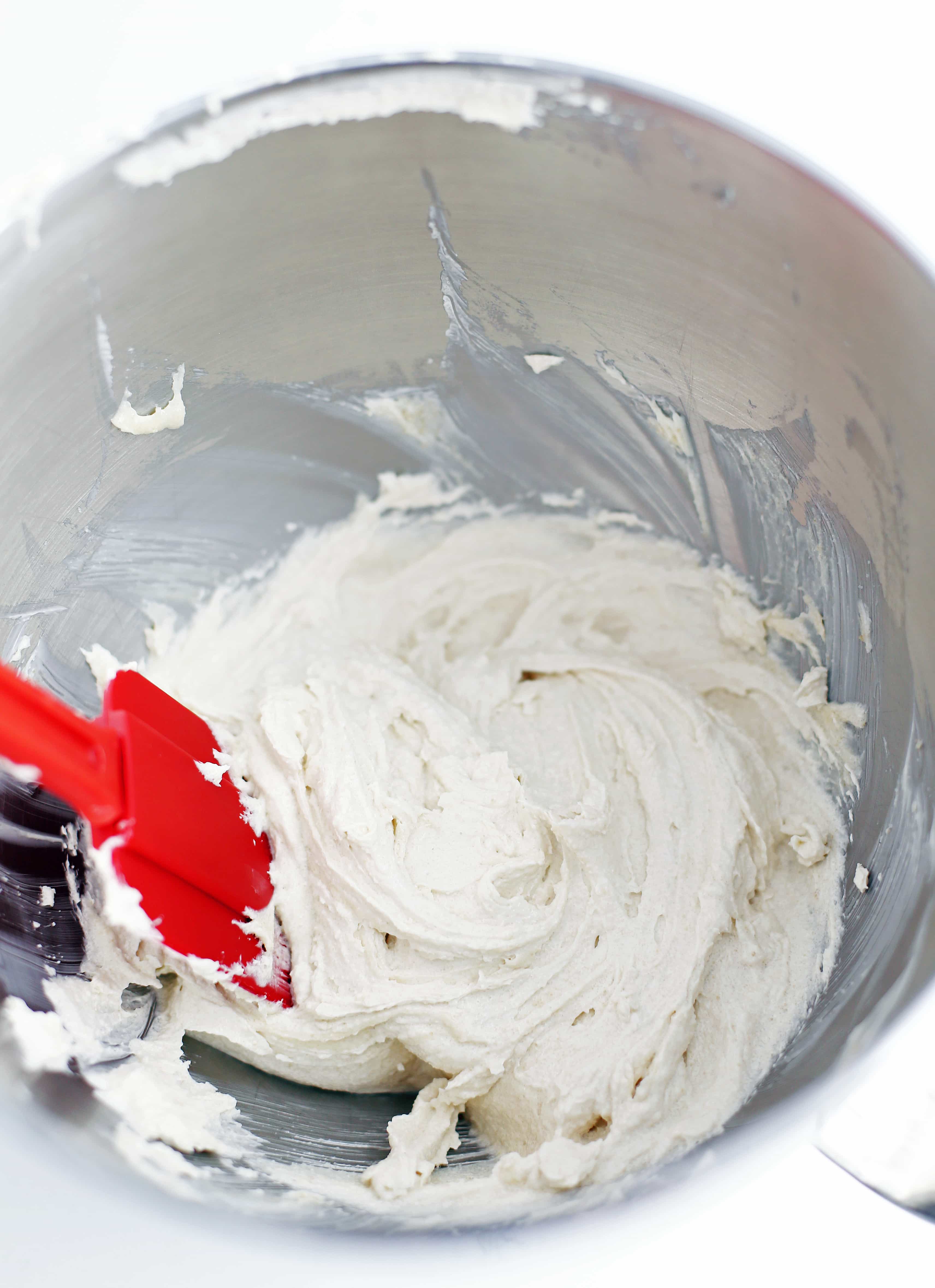 Whipped butter and sugar in a stainless steel bowl.